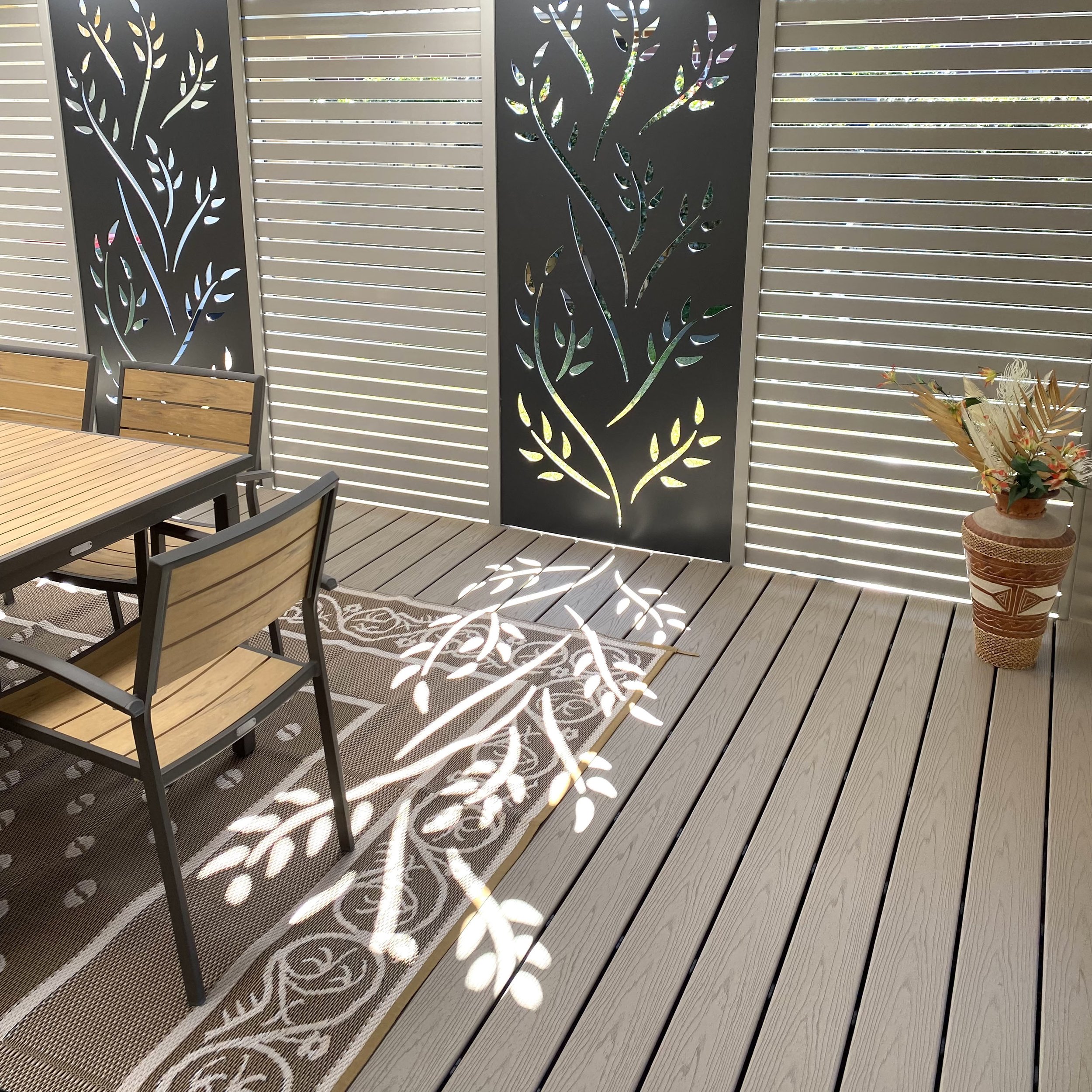 Luxury outdoor dining zone framed with custom privacy panels built by Platinum Decks to enhance high‑end entertaining with coastal‑grade materials