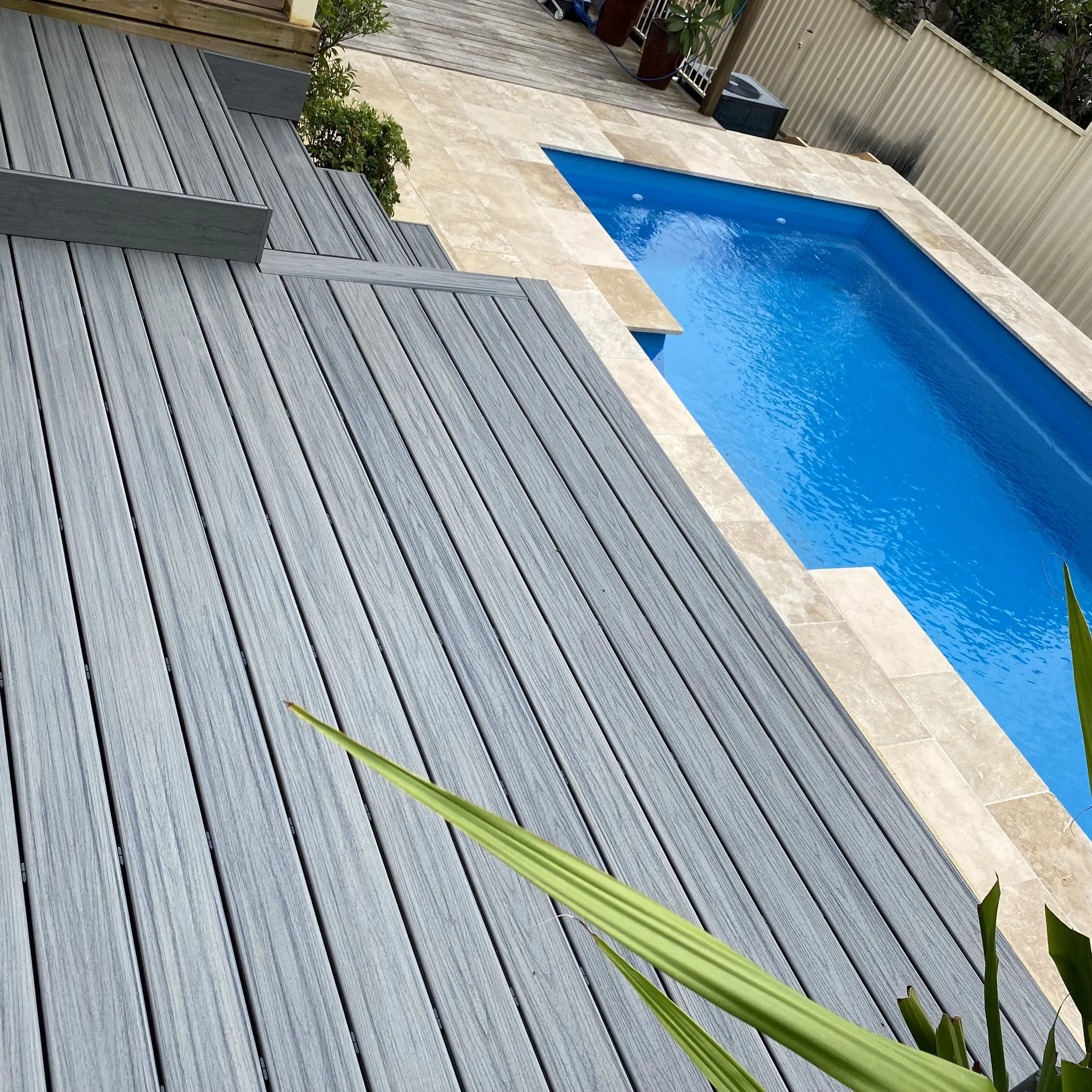 Trex pool deck, stone patio and privacy fencing enhanced by Platinum Decks to create a clean, modern outdoor living zone