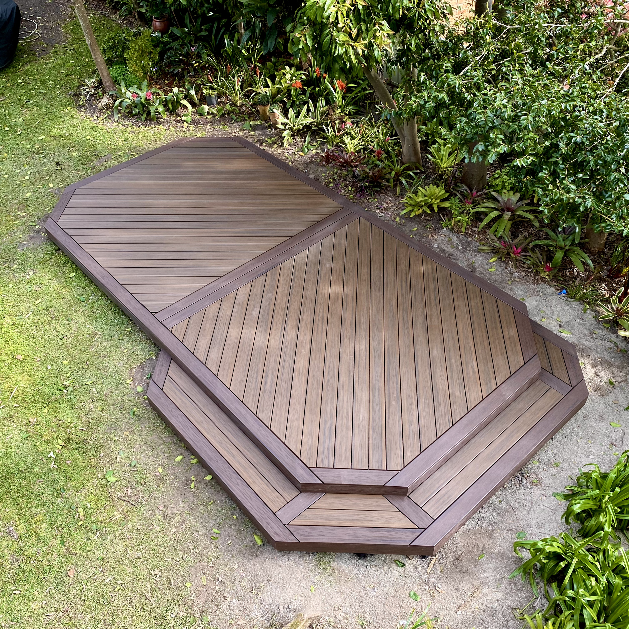 Composite platform designed for easy year‑round care tucked into garden greenery, completed by Platinum Decks as a calm outdoor spot