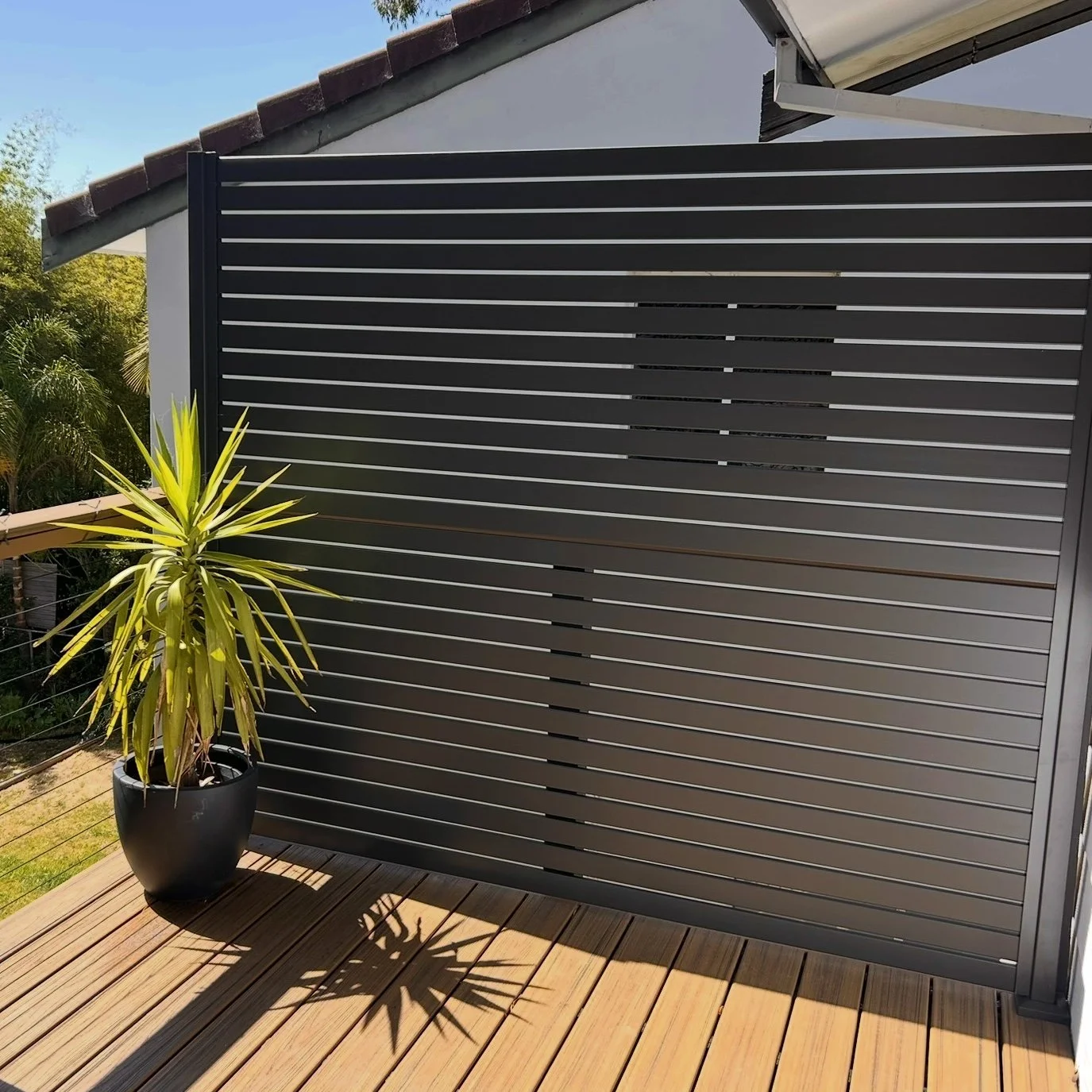 High‑end slatted wall feature styled for contemporary outdoor areas built by Platinum Decks to enhance privacy while maintaining a luxury coastal aesthetic