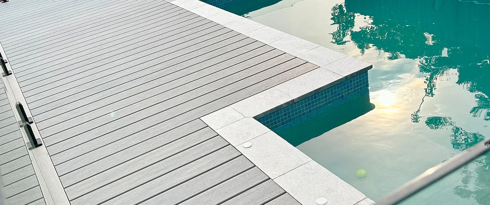 Modern swimming pool with Trex decking in Rainer and reflective water surface completed by Platinum Decks to highlight refined, minimalist poolside design
