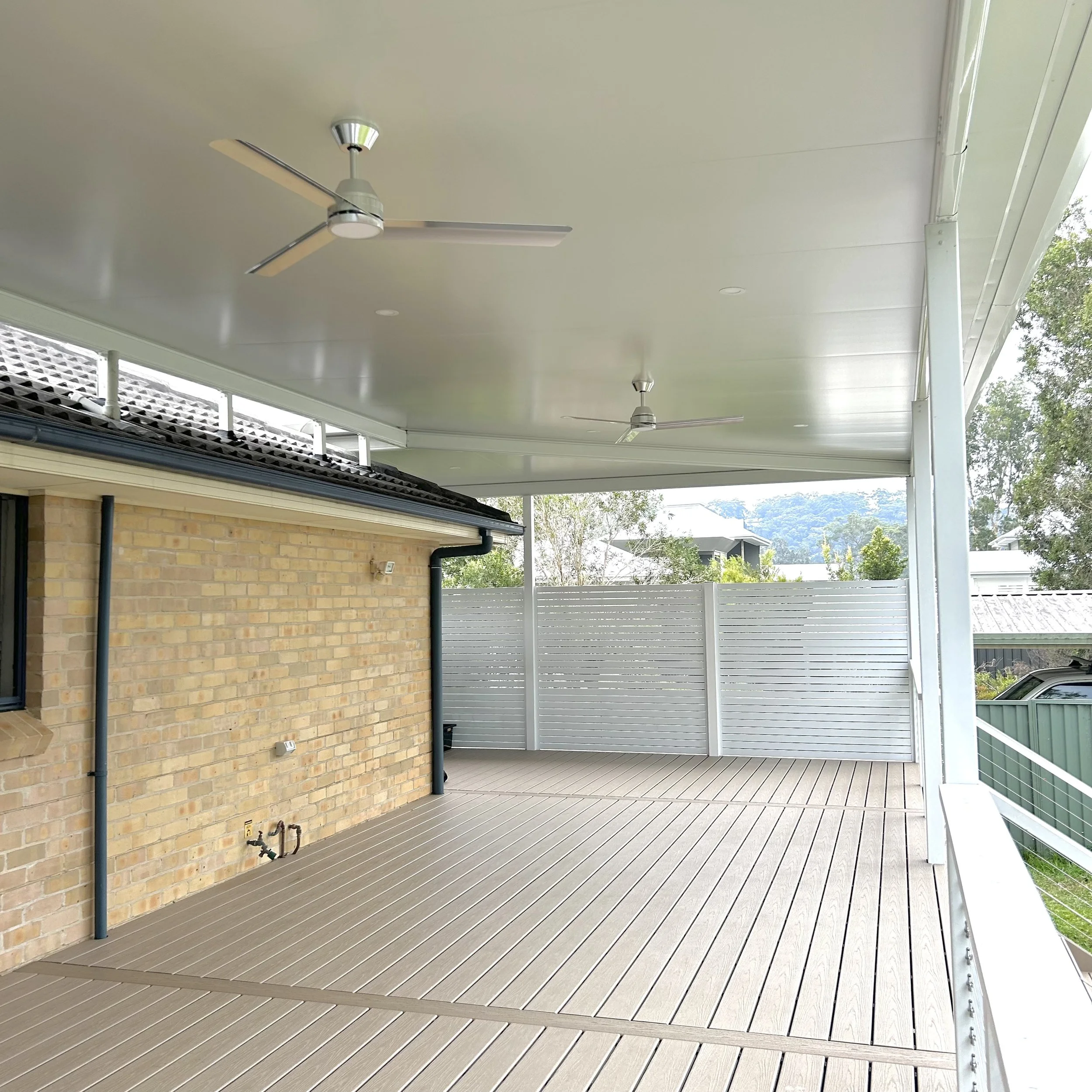 White Stratco Outback Cooldek patio with ceiling fans and elevated outdoor living zone enhanced, with Trex deck in rope swing by Platinum Decks to provide a premium, breezy entertaining area