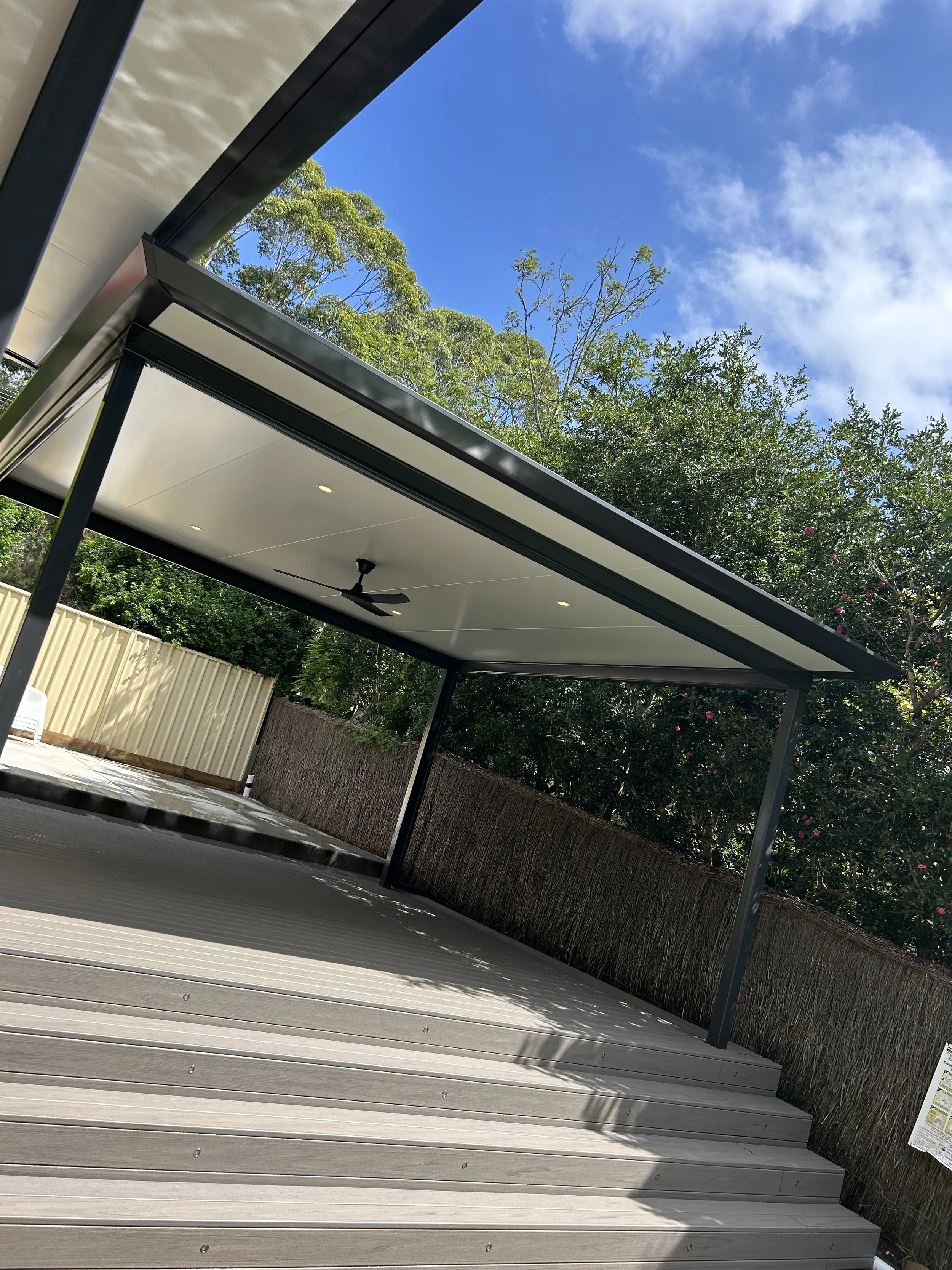 Stratco Outback Cooldek patio with ceiling fan, Trex decking and privacy fencing crafted by Platinum Decks to create a premium, sheltered alfresco zone