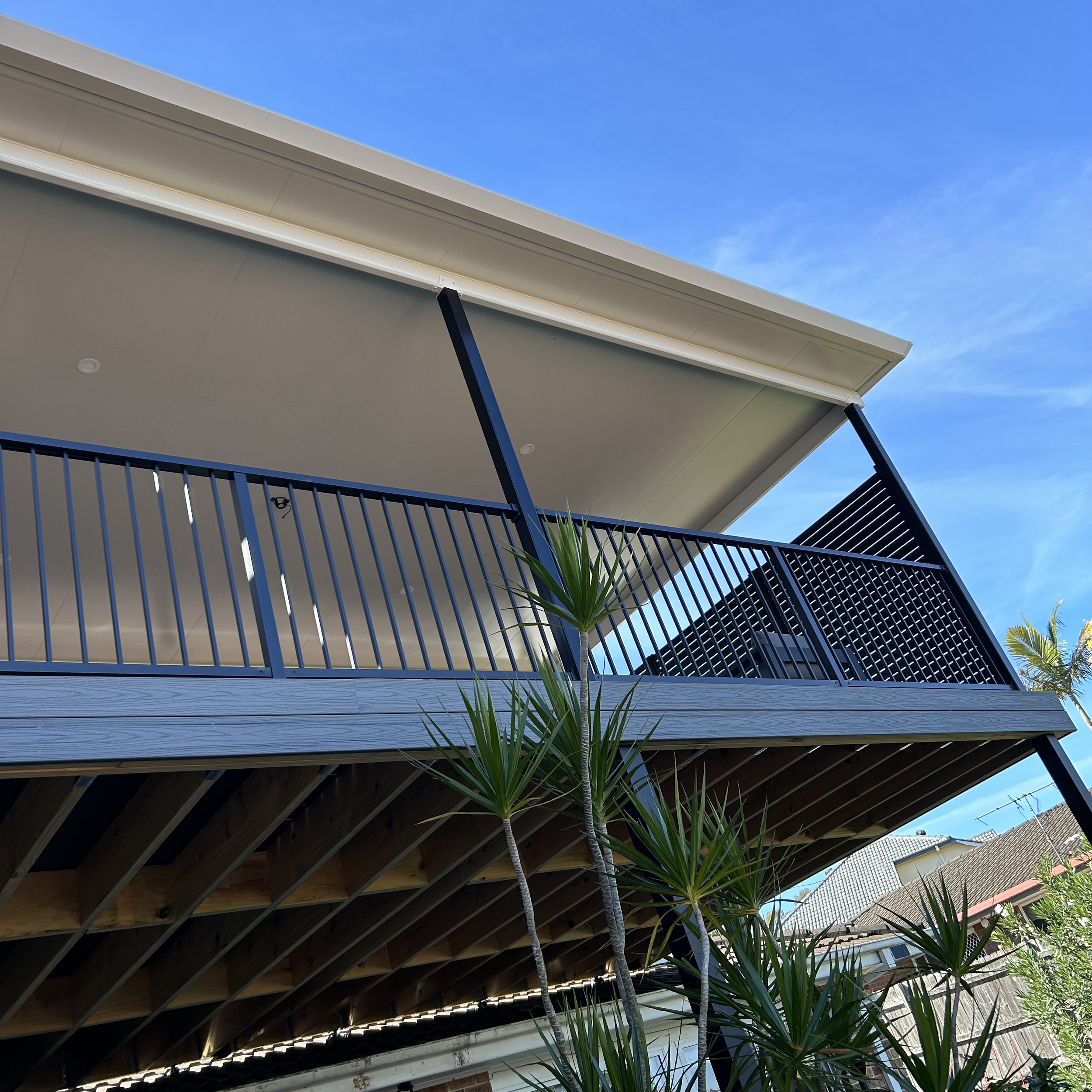 High‑end composite patio with black balustrades and custom designed patio roof completed by Platinum Decks to create a premium outdoor living zone suited to Central Coast homes