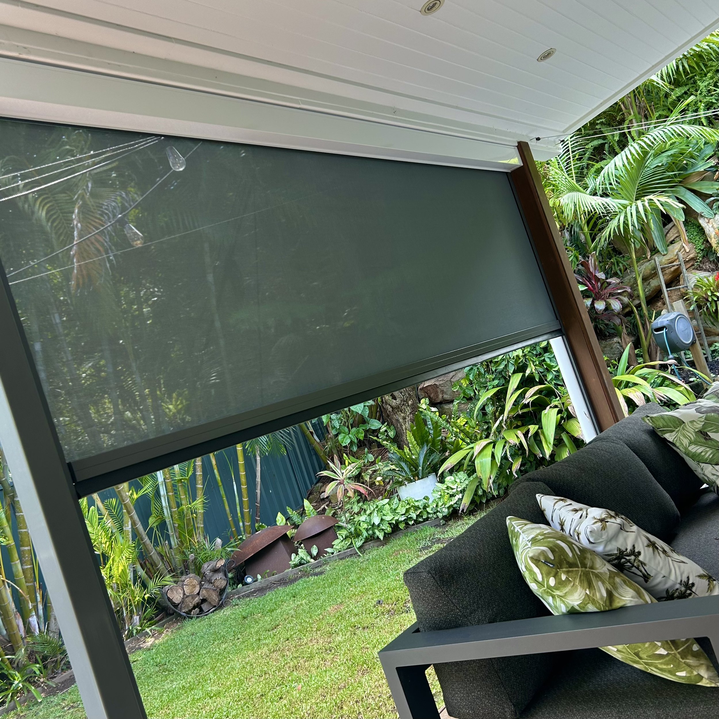 Custom made privacy blinds installed by Platinum Decks on a deck overlooking lush tropical garden. 