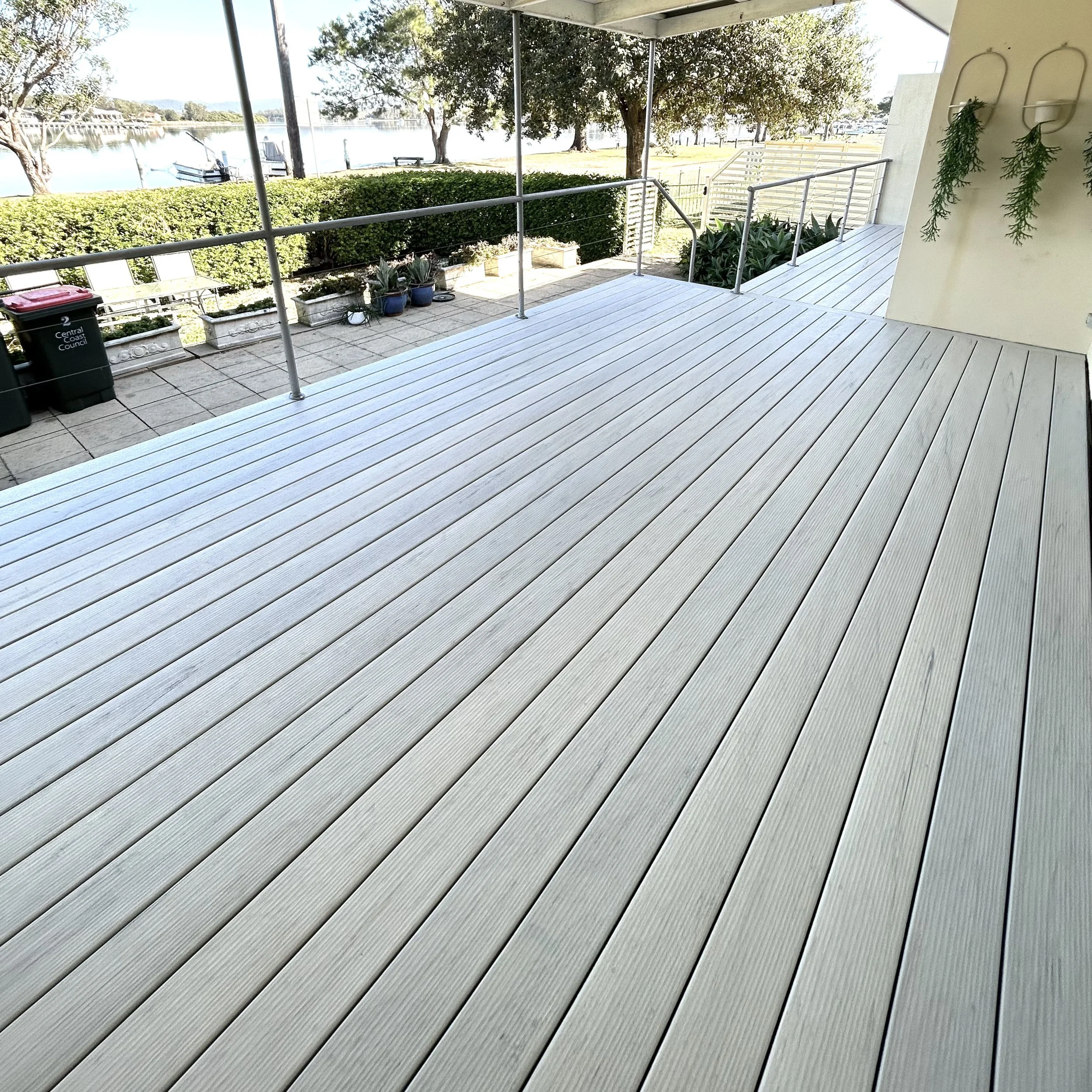 
White timbertech patio deck overlooking river and landscaped views designed by Platinum Decks to elevate alfresco living with a luxury waterfront feel