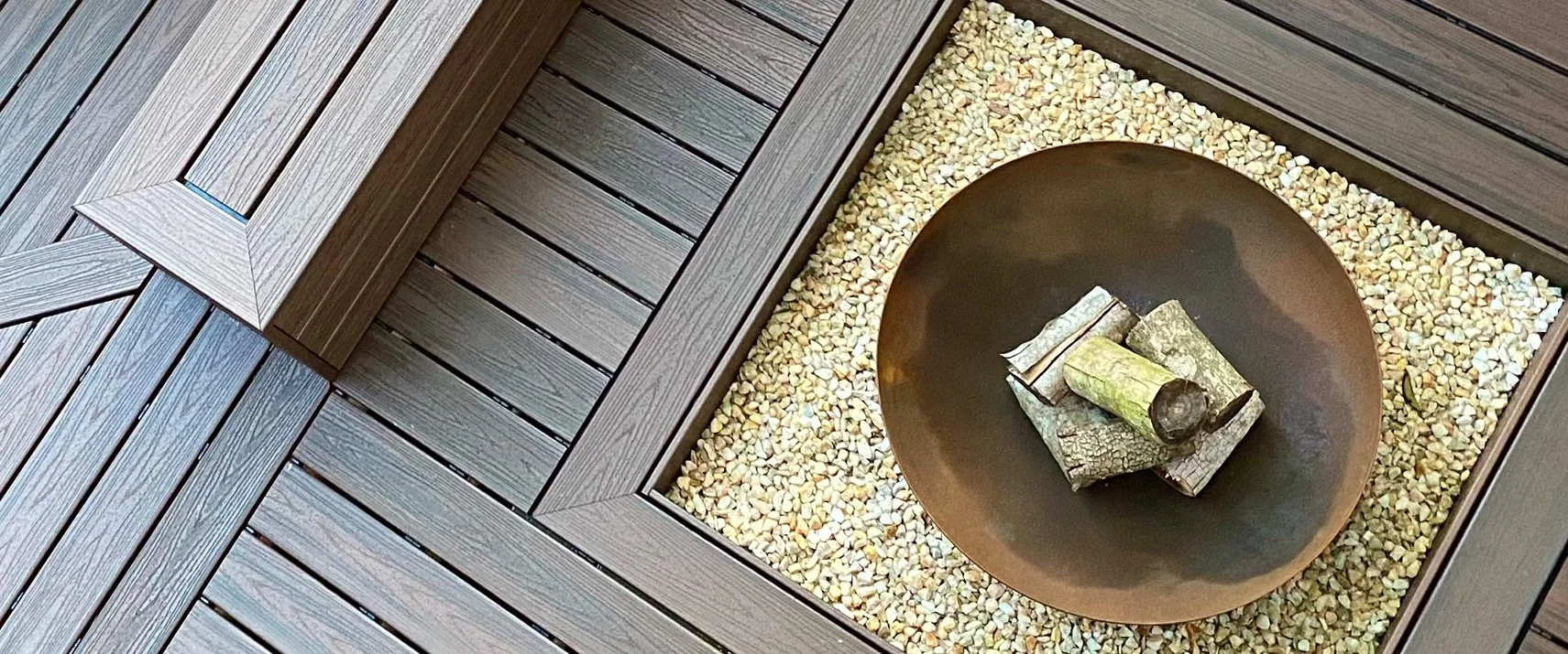Built in fire pit area with composite decking and stone surrounds by Platinum Decks & Patios for outdoor gatherings