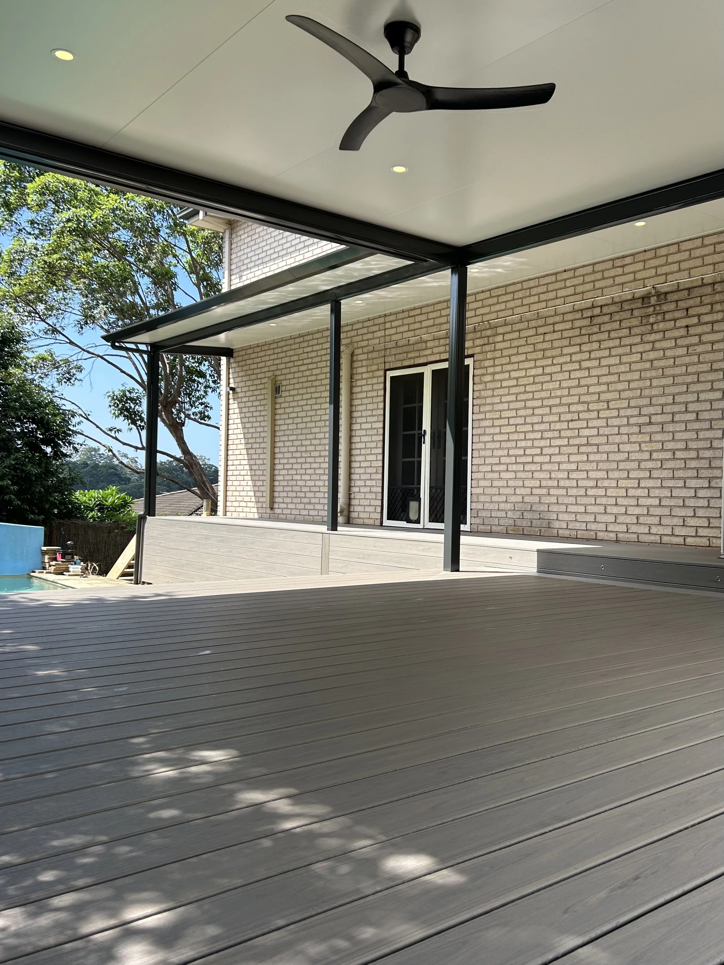 Stratco outback patio with ceiling fan and Trex composite deck in biscyane crafted by Platinum Decks to create a cool, comfortable outdoor retreat