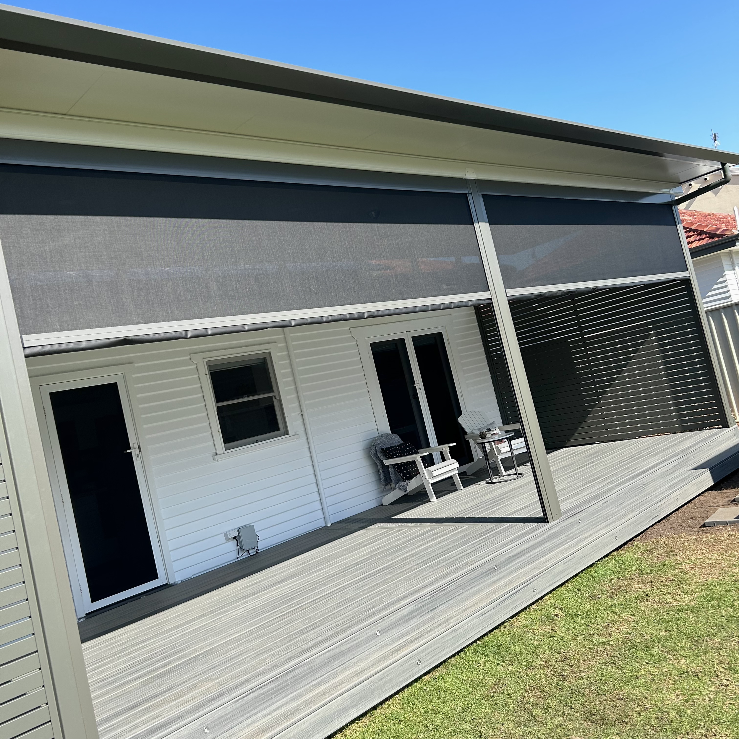 Composite deck with retractable outdoor blinds, forming a flexible and enclosed alfresco space built by Platinum Decks - Patios and Outdoor Living