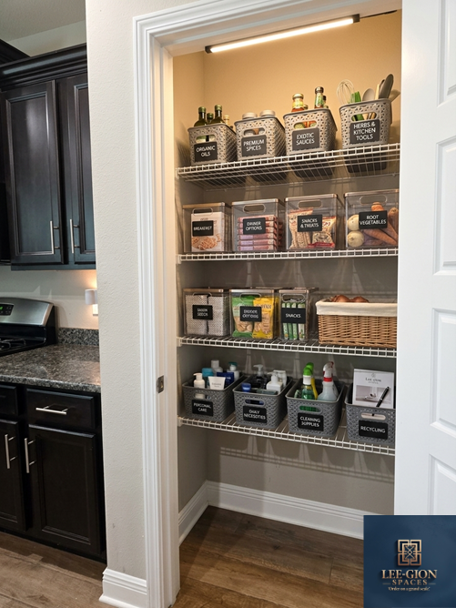 Pantry with four wire shelves filled with labeled jars, boxes, and bins containing spices, sauces, snacks, and cleaning supplies in a kitchen closet.