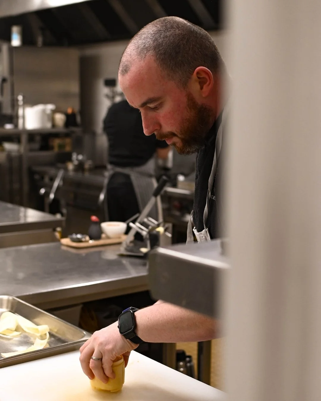 Un chef en cuisine prépare un plat en utilisant ses mains.