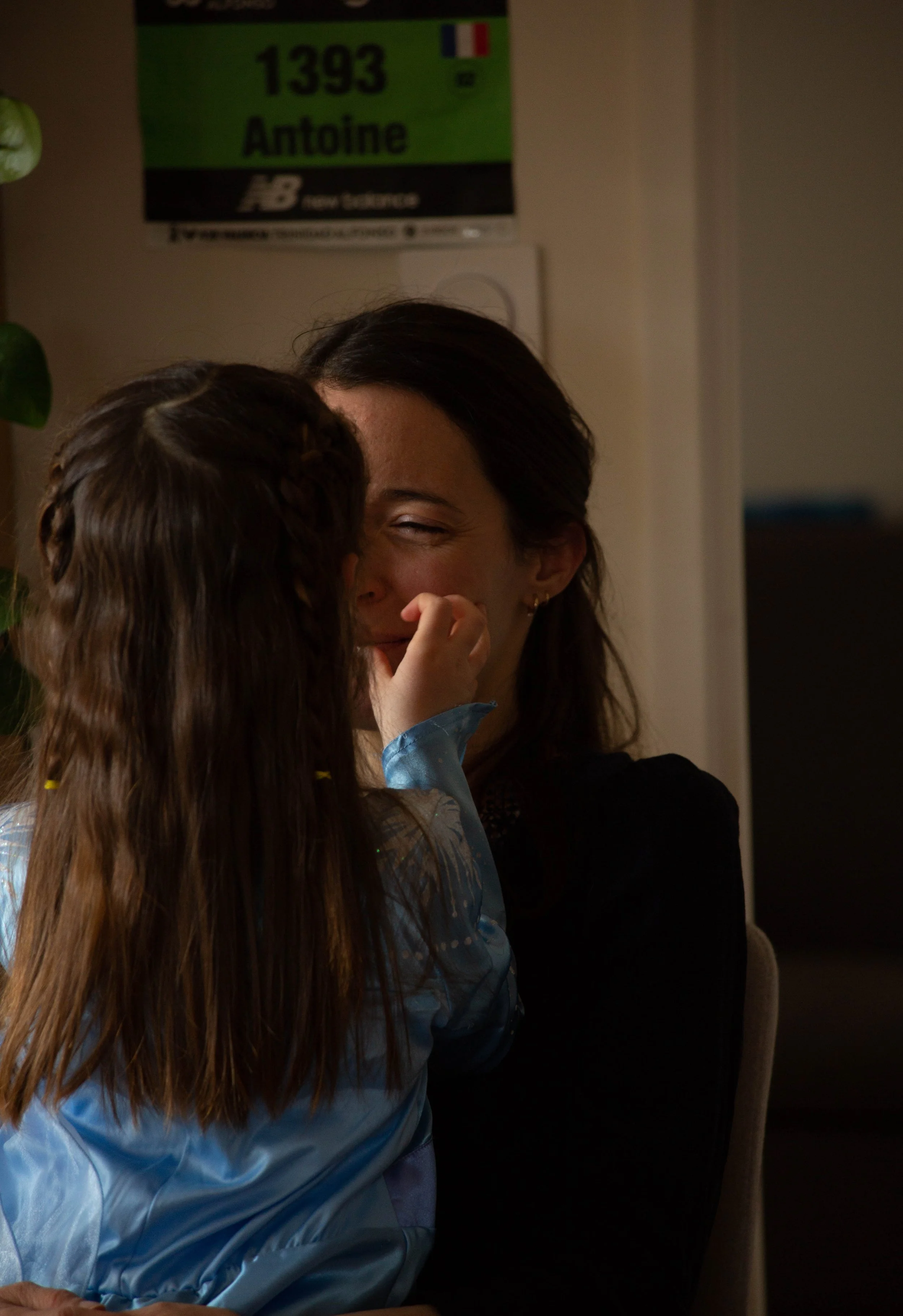 Une femme souriante dès que son enfant lui fait un bisou sur la joue.