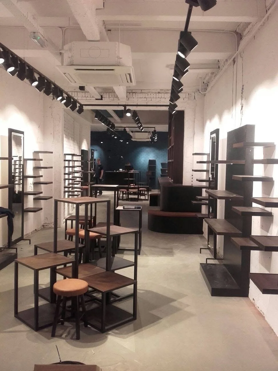 Binnenruimte van een café of winkel met lege planken en meubels klaar voor inrichting.
