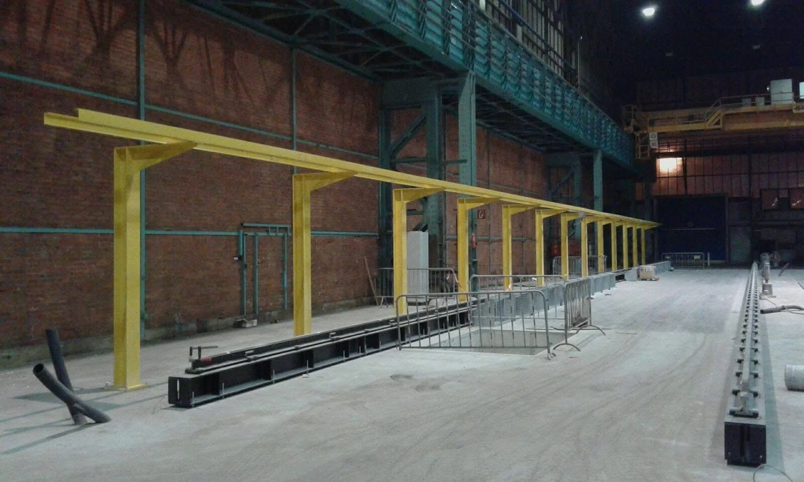 Binnenplaats van een bouwplaats met technische installaties en metalen structuur, klaar voor verdere bouwactiviteiten.