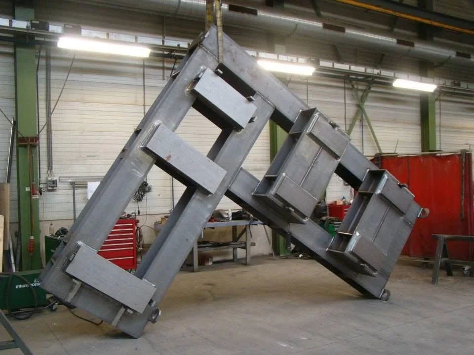Een industriële workshop met een metalen constructie die ondersteboven hangt.