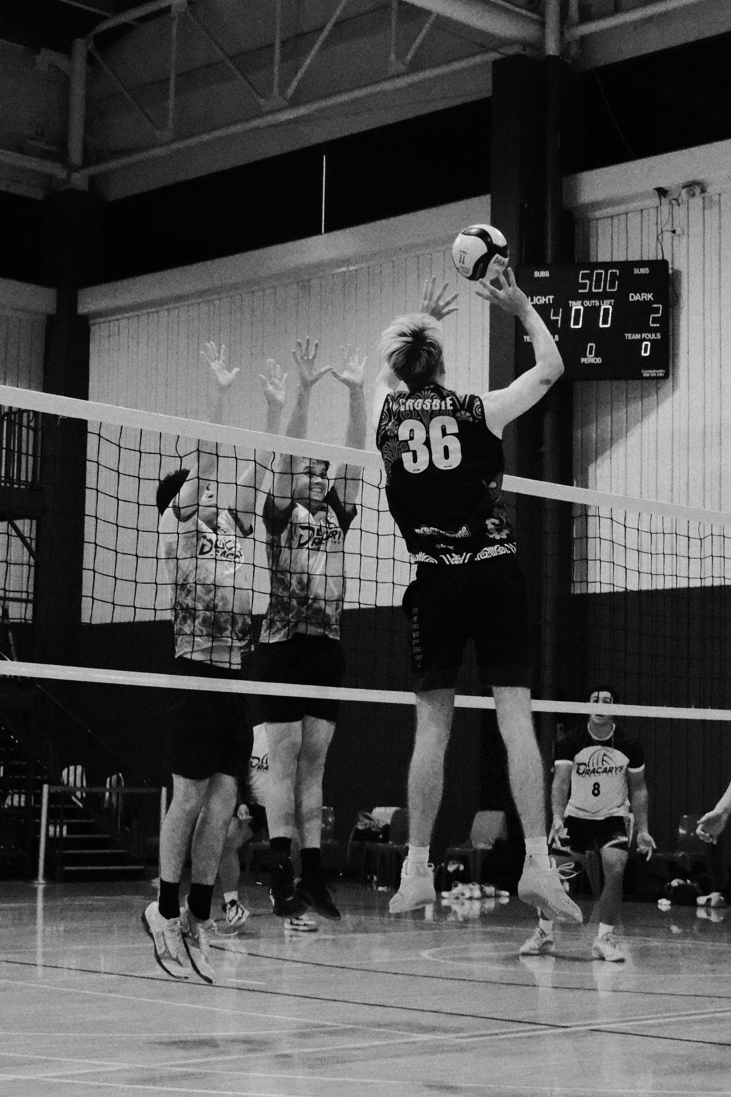A volleyball game in progress inside a gymnasium with players jumping near the net and a scoreboard in the background showing 50 points for the home team, 2 points for the visitors, and 400 seconds remaining.