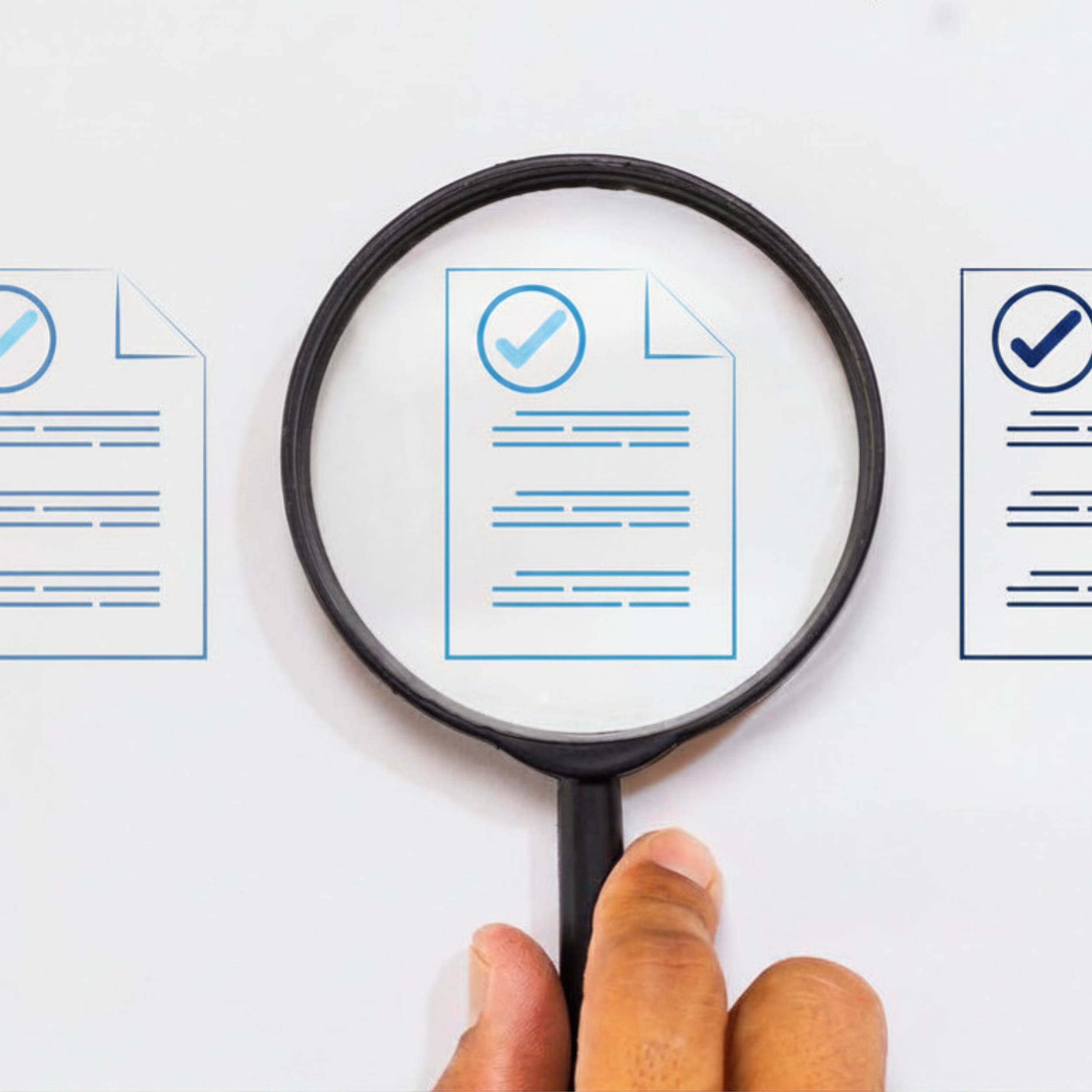 A person's hand holding a black rubber belt above printed graphics of check marks and documents on white paper.