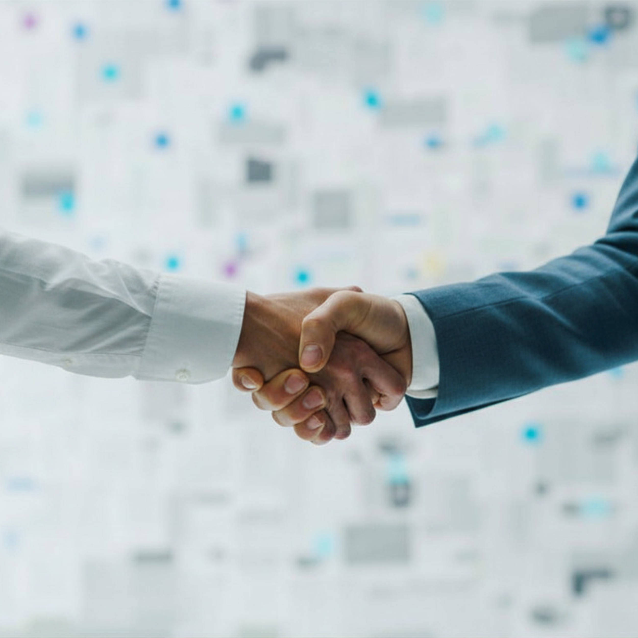 Two people in professional attire shaking hands in front of a wall with colorful pinned notes or information.