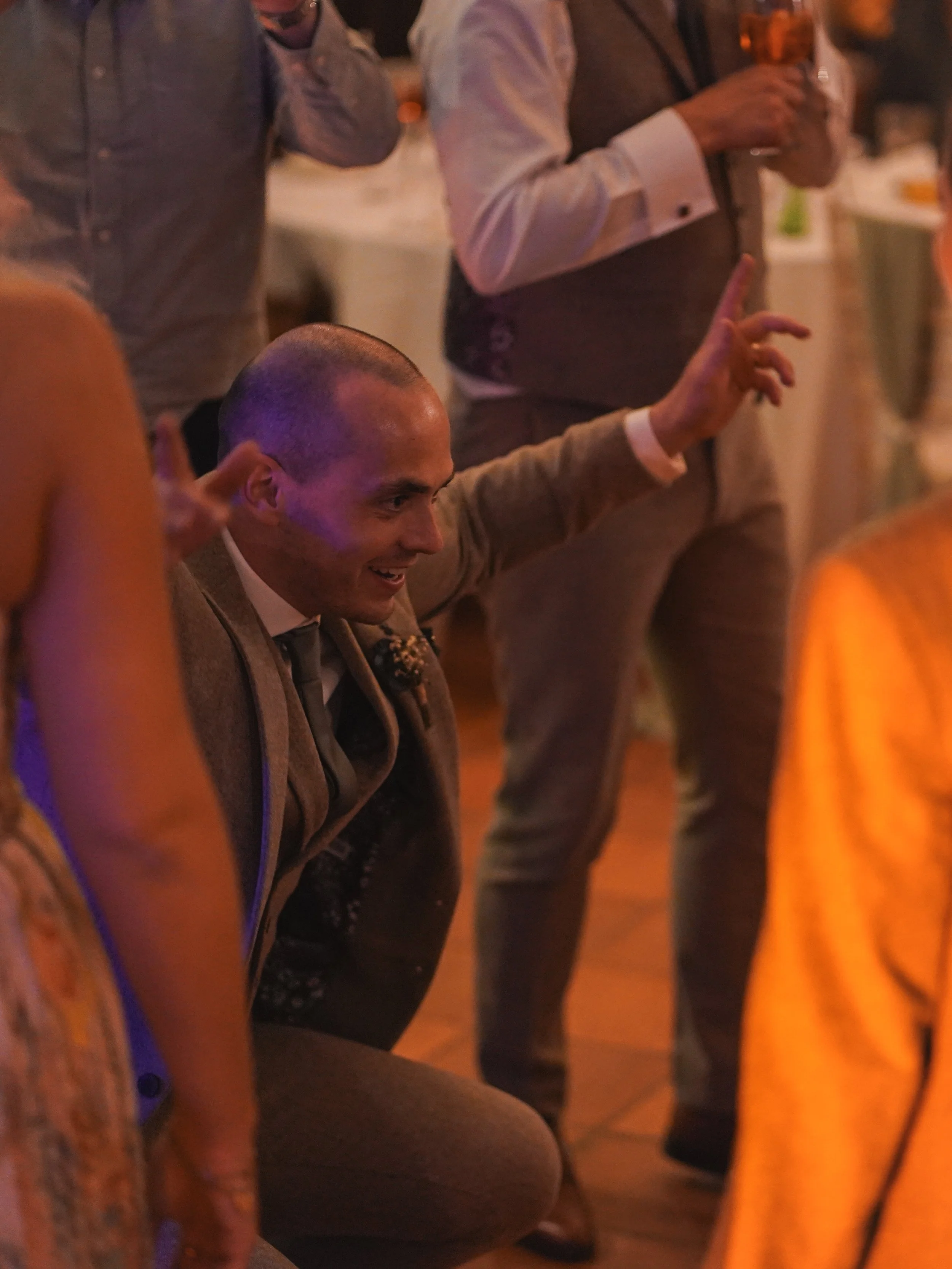 People at a social gathering or party, standing close together, holding drinks, and engaging in conversation.