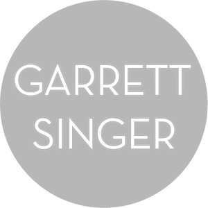 Gray circle with white text reading 'GARETT SINGER'.
