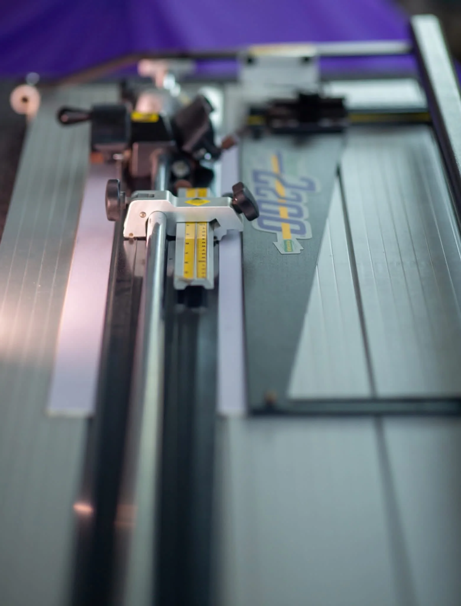 Close-up of a metal camera slider with a mounted camera, setup on a flat surface.