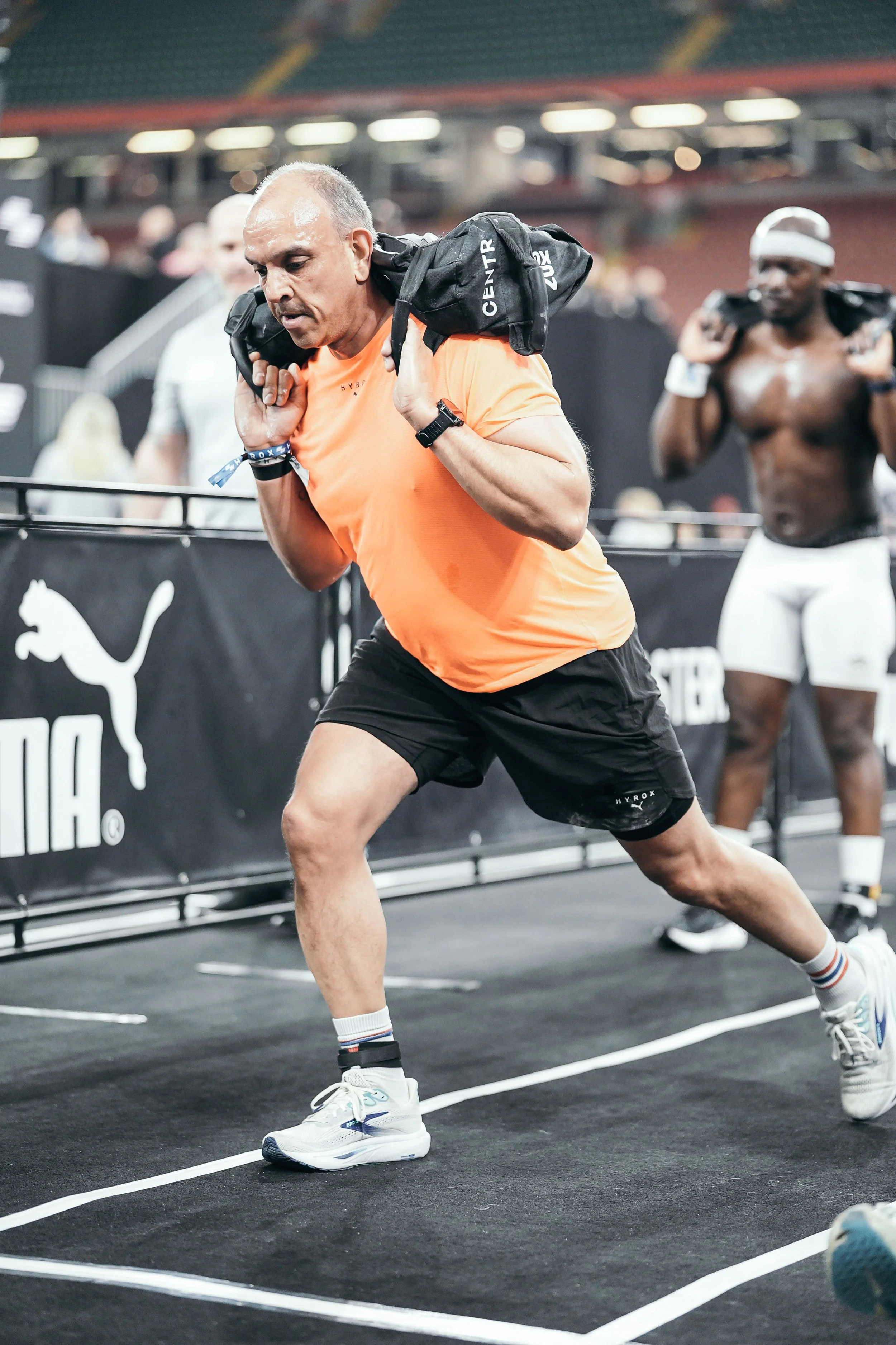 The Engine Room member doing sandbag lunges at HYROX