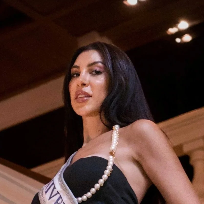 Close portrait of a woman in a strapless black dress and pearl necklace with a pageant sash, Bangkok photoshoot