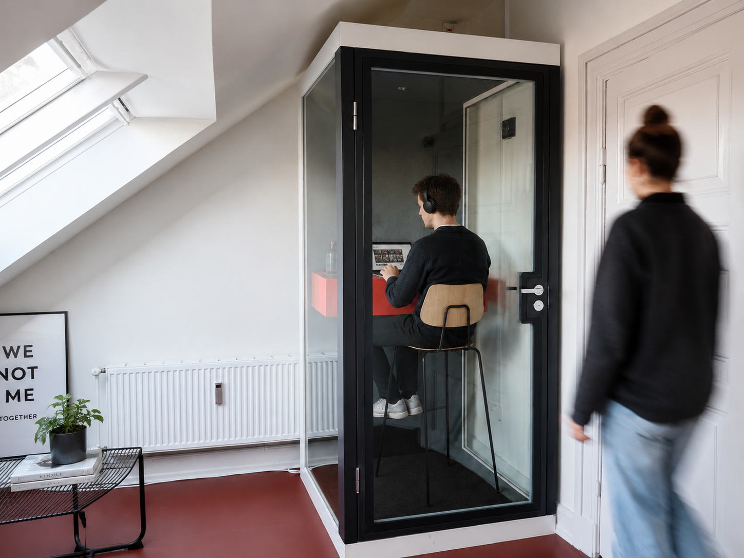 Mand med høretelefoner og bærbar computer i en telefonboks hos ToTo
