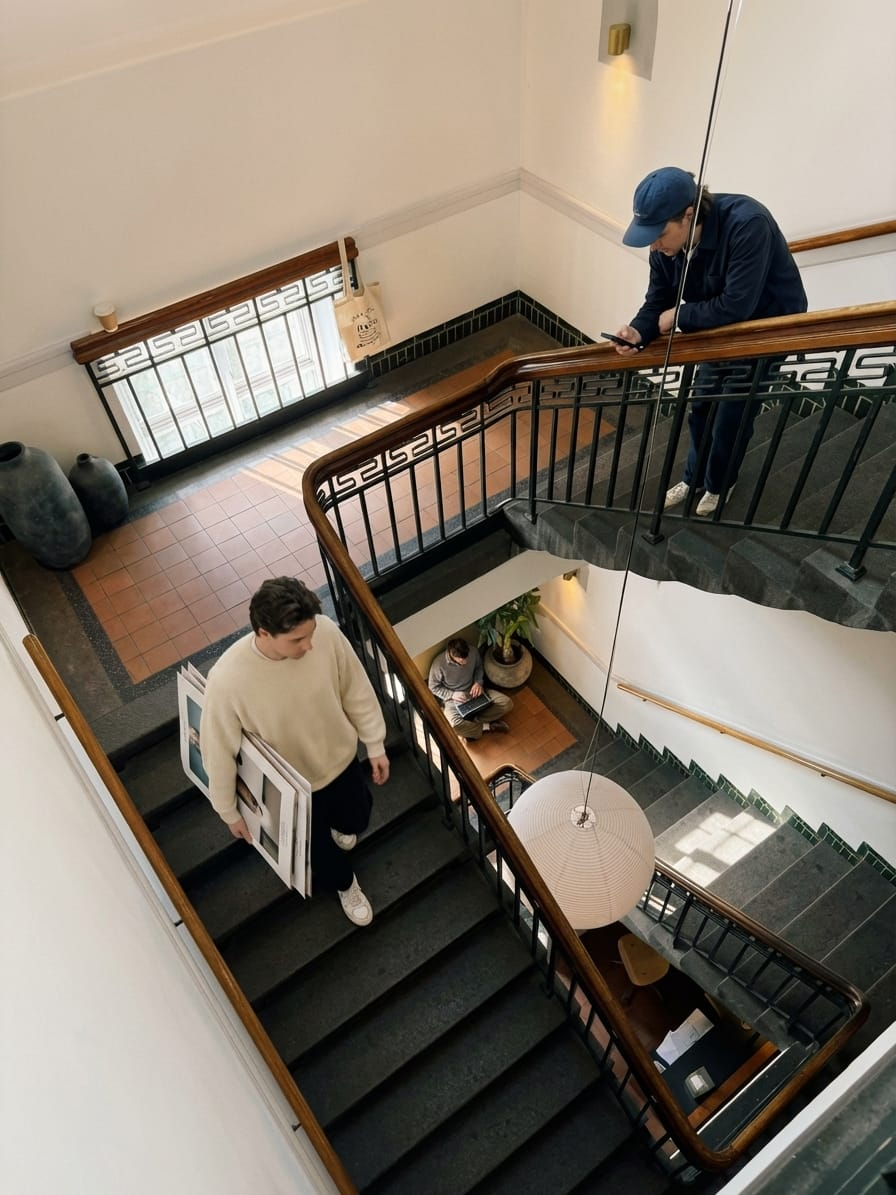 Trappeopgang med originale gelændere og mennesker på vej mellem etagerne hos ToTo