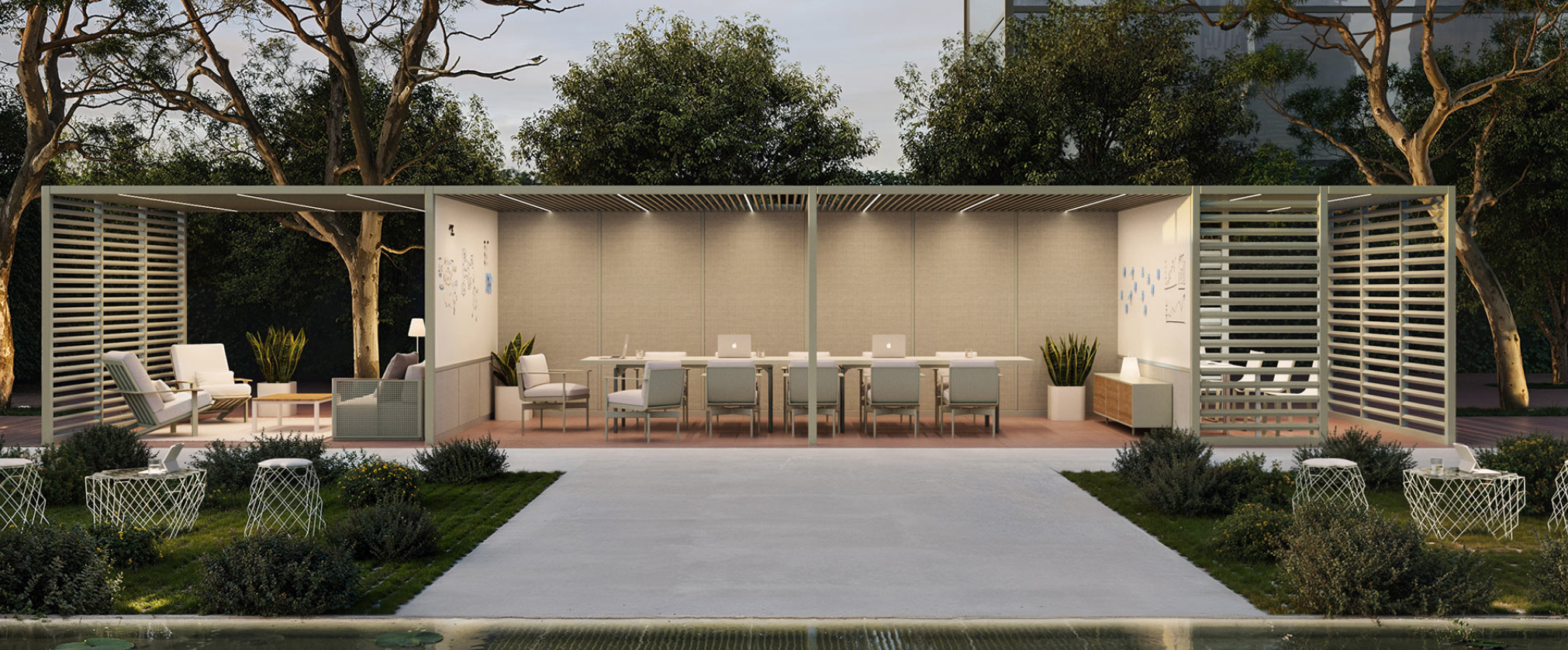 Modern outdoor pavilion with seating and workspaces, surrounded by trees and greenery at dusk.