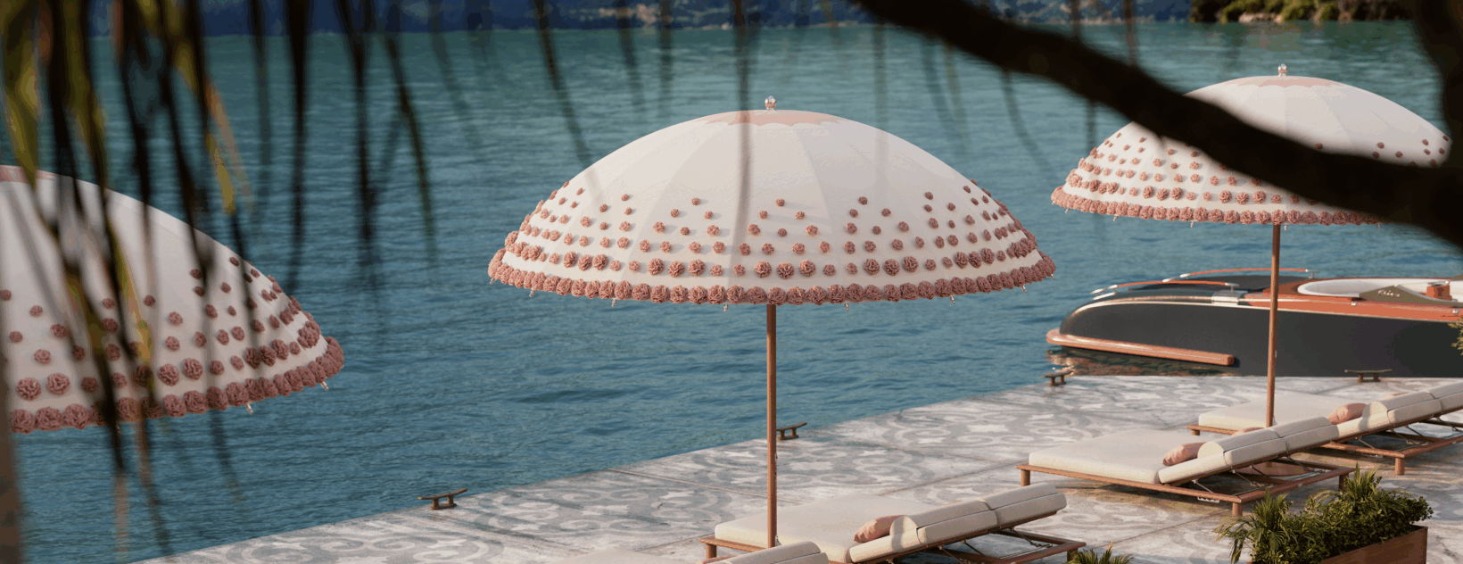 A poolside scene with several pink and white umbrellas, lounge chairs, and a boat on the water, viewed through tree branches.