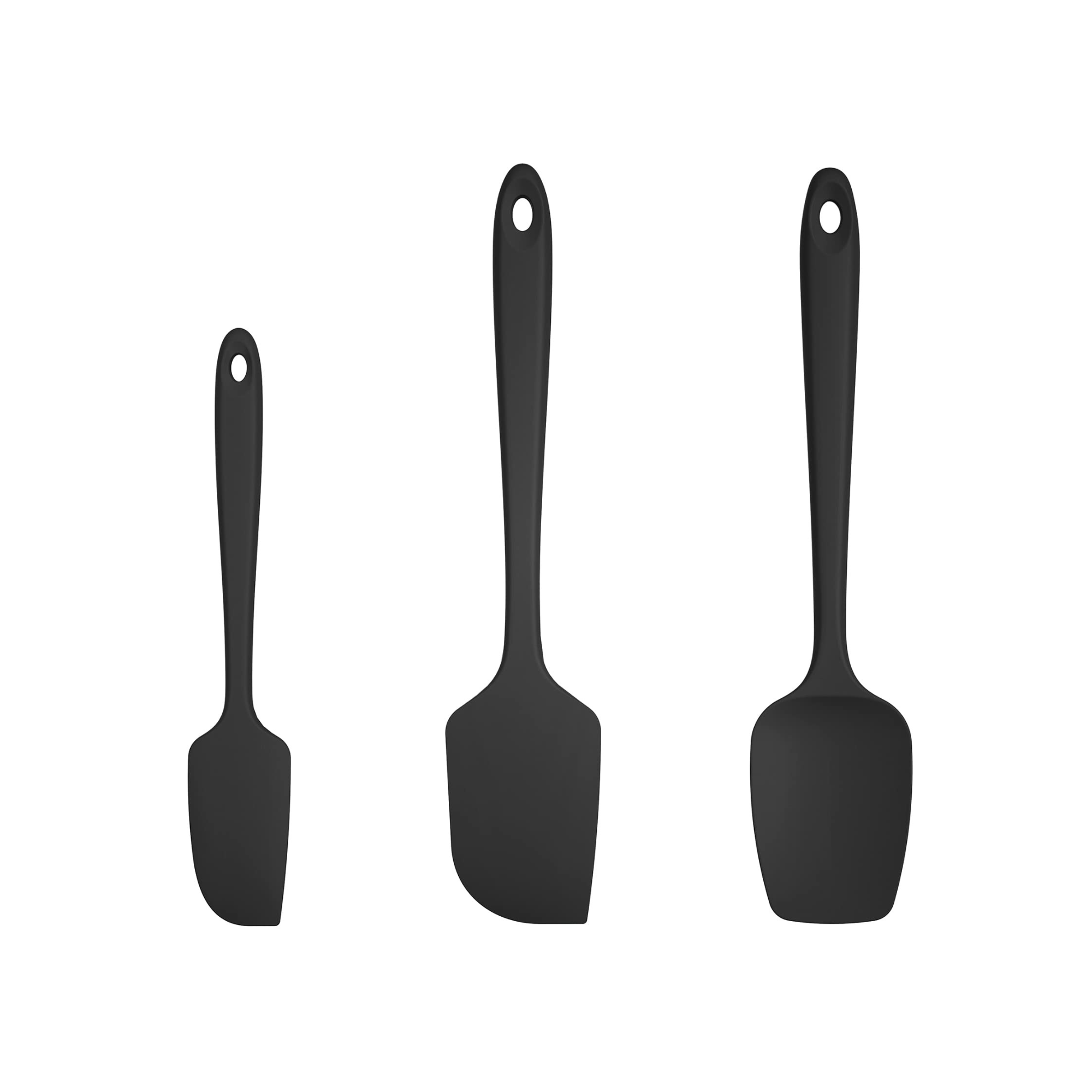 Four black knives with black handles standing upright on a flat surface.
