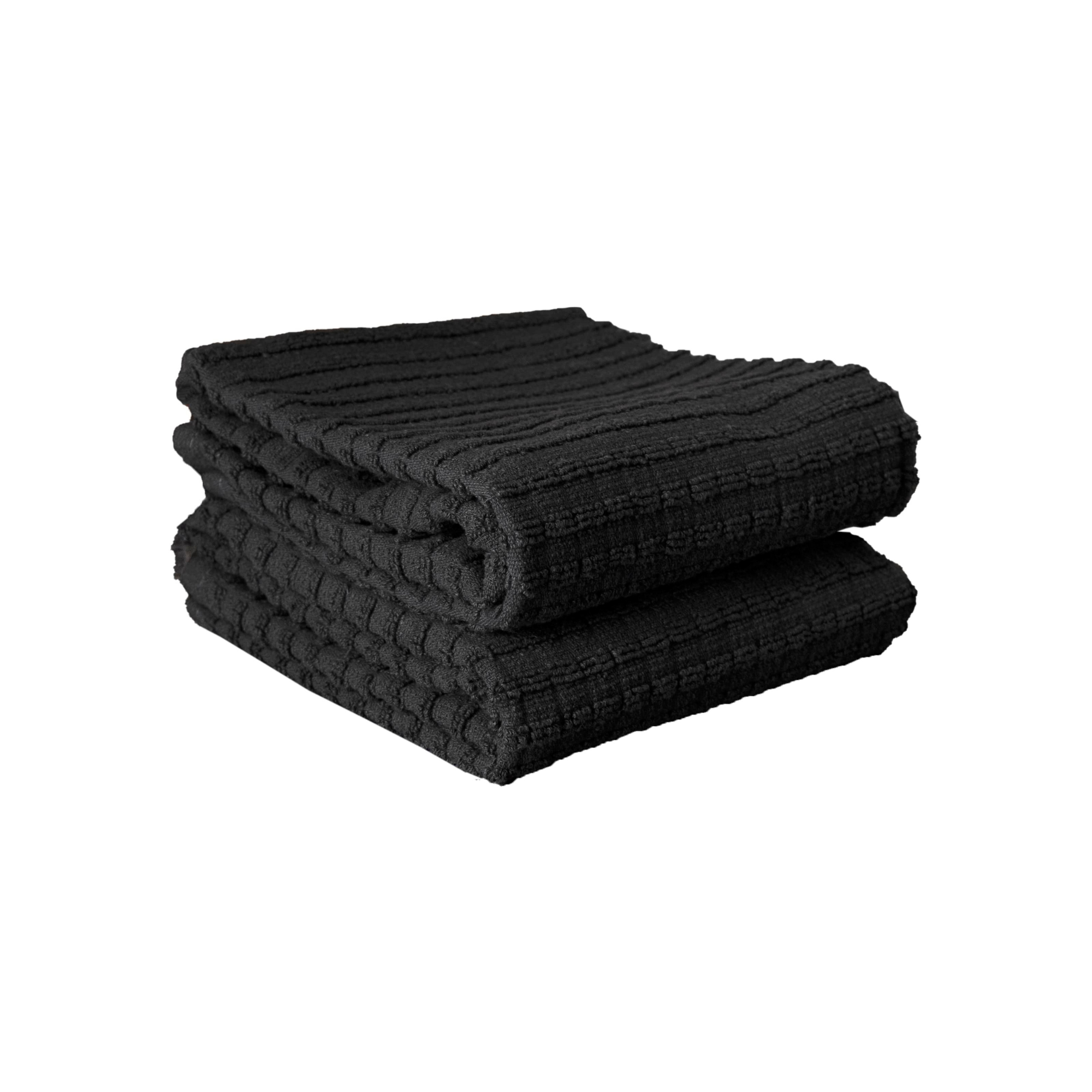 Stack of folded black towels with ribbed texture against white background.