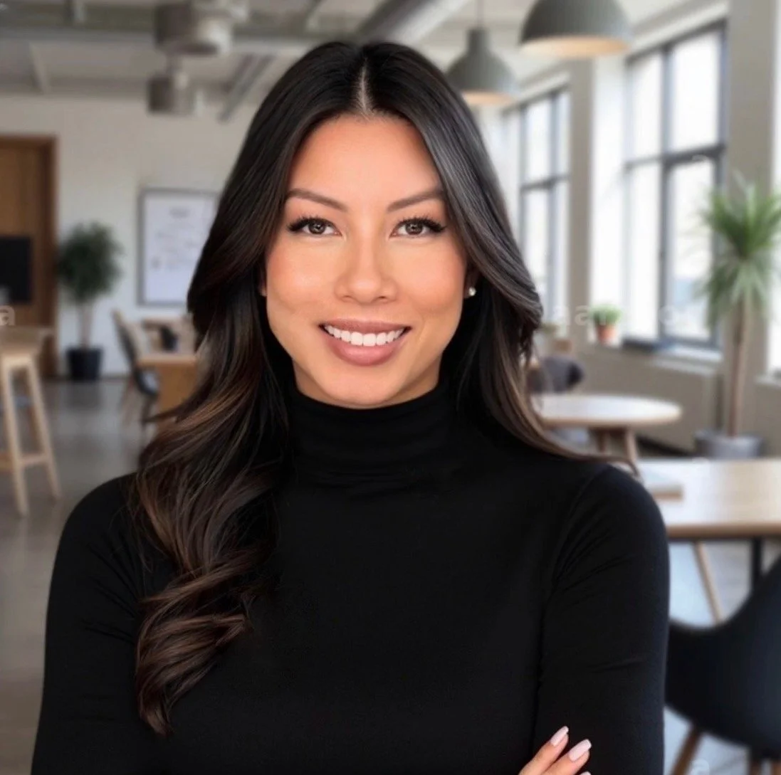 Crystal Quan of Elevate Realty Group, a woman with long dark hair smiling in an office setting with large windows, plants, and modern furniture in the background.