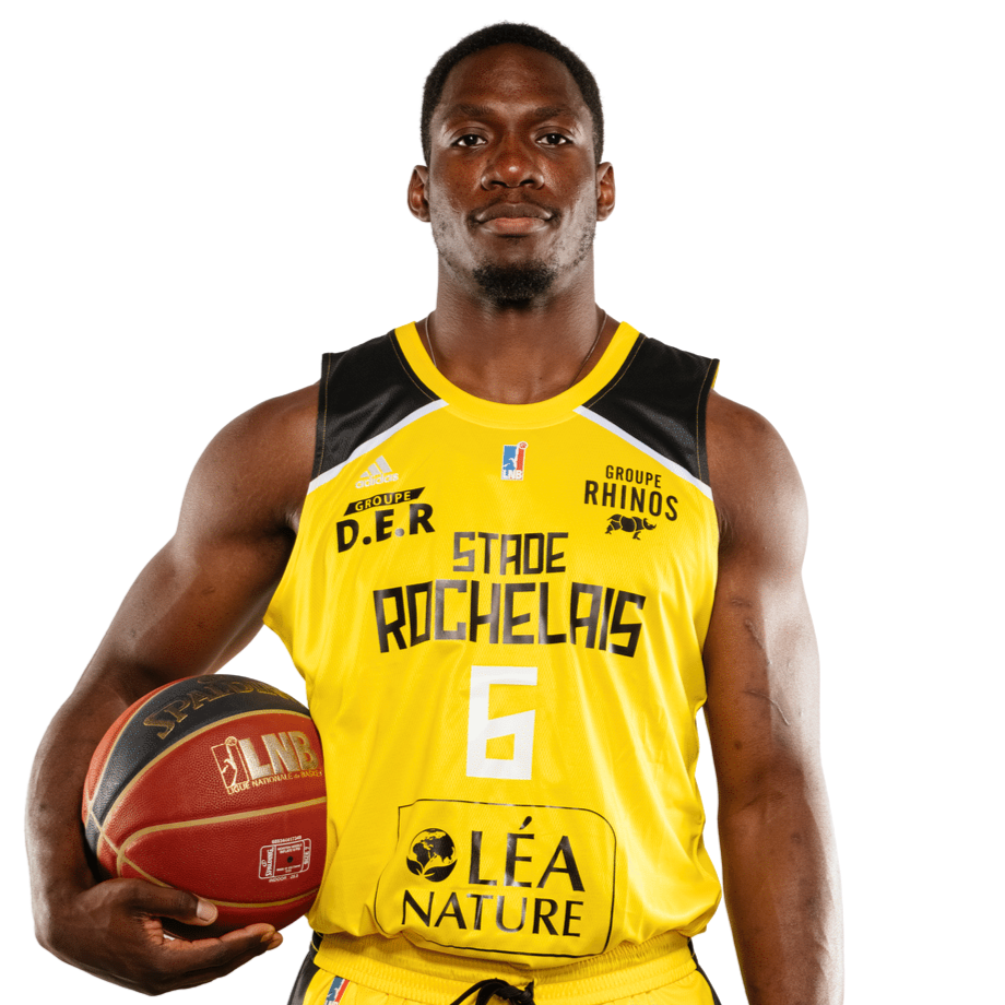 A male basketball player in a yellow and black Stade Rochelais jersey holding a basketball in his right hand.