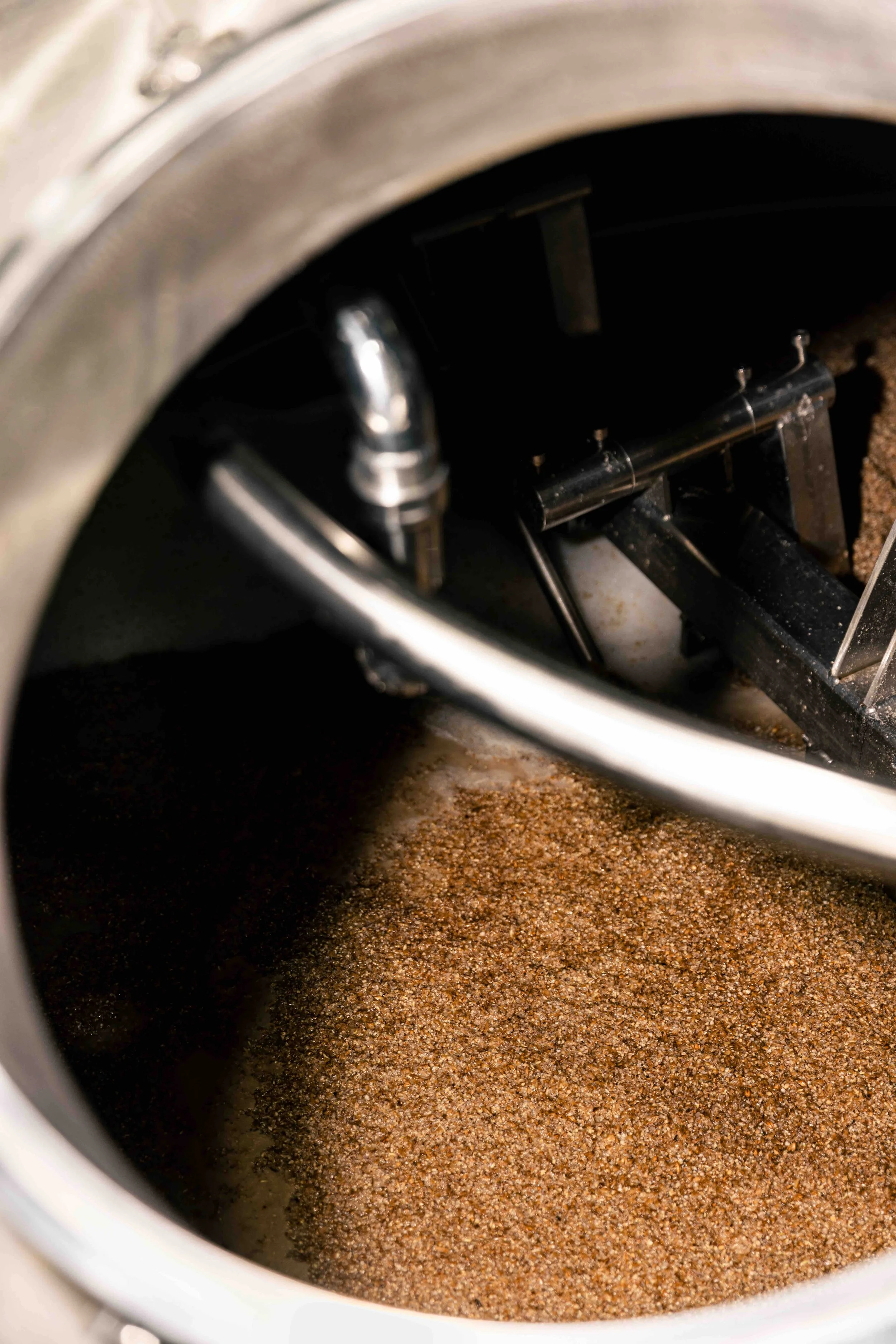 The image shows the inside of a coffee machine's brew basket filled with dry, ground coffee.