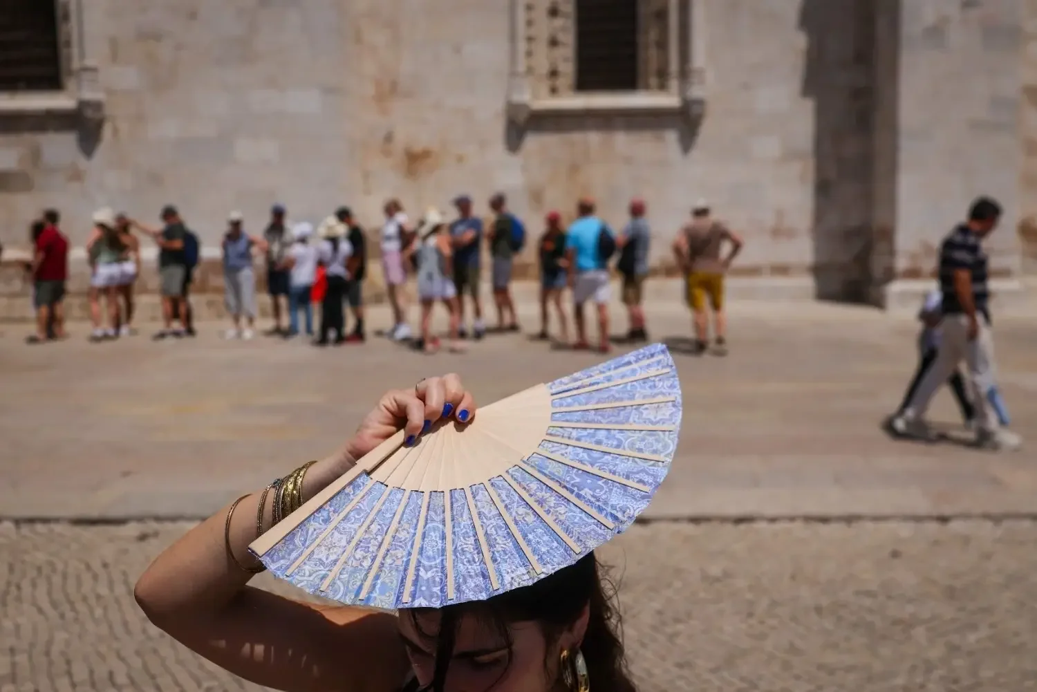 Woman bracing Madrid heat with fan