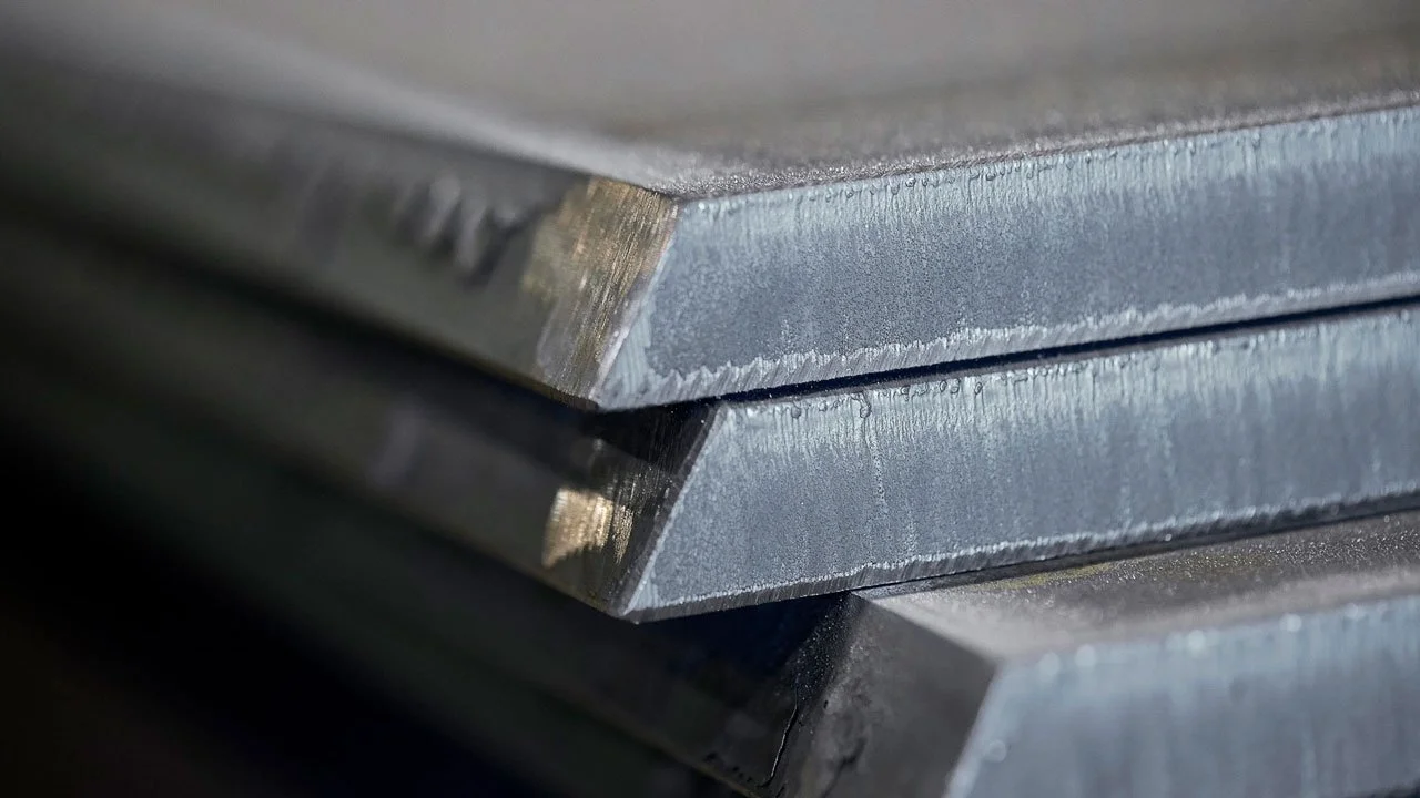 Close-up of stacked metal sheets with sharp edges.