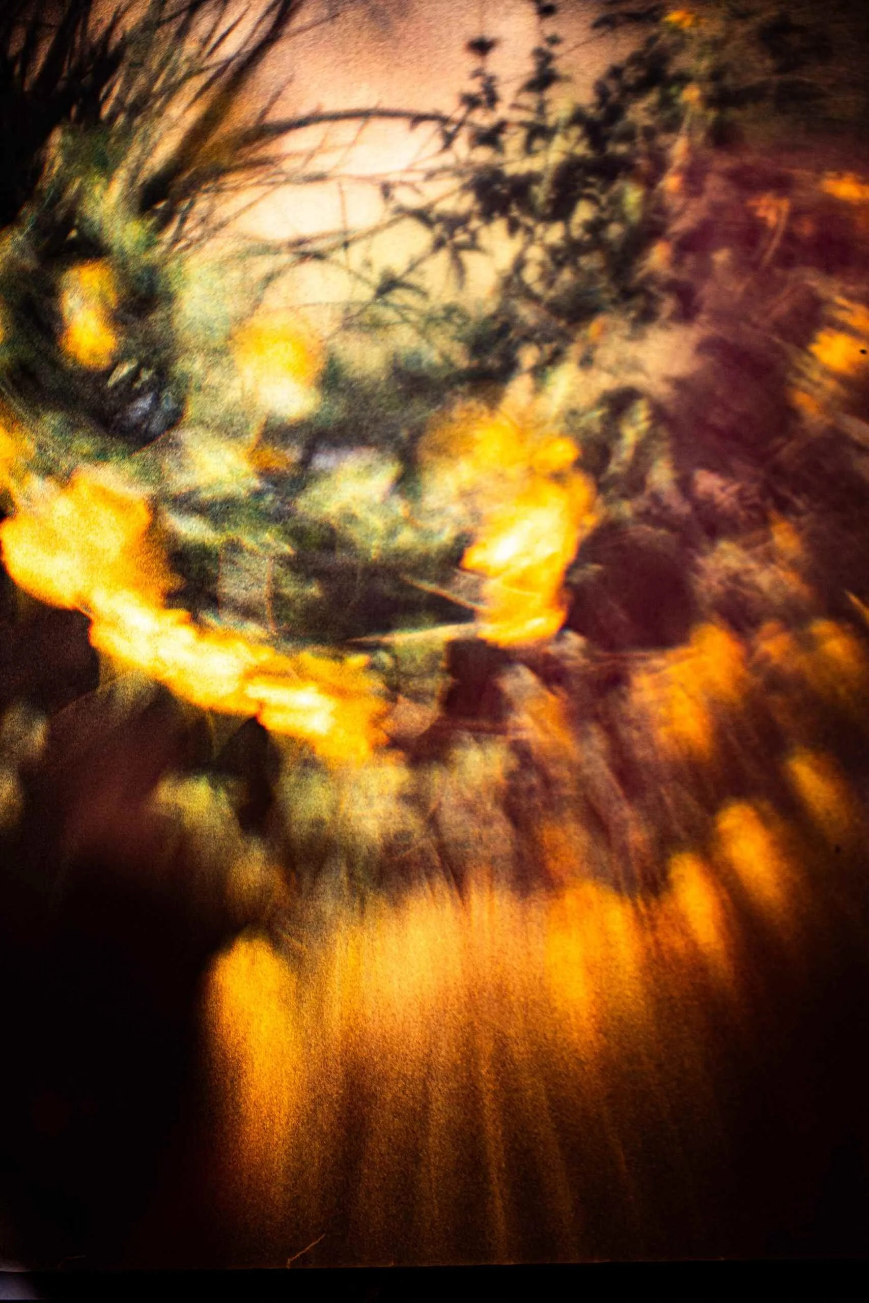 Artwork for Cloudbursts piece in Blood Orange Review. Blurry image of a fire with flames and smoke, surrounded by darkness. 