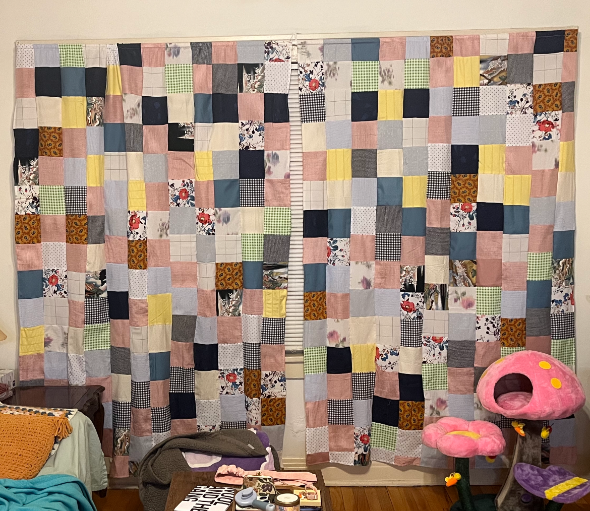 Colorful patchwork curtains with various fabric patterns hanging on a wall.