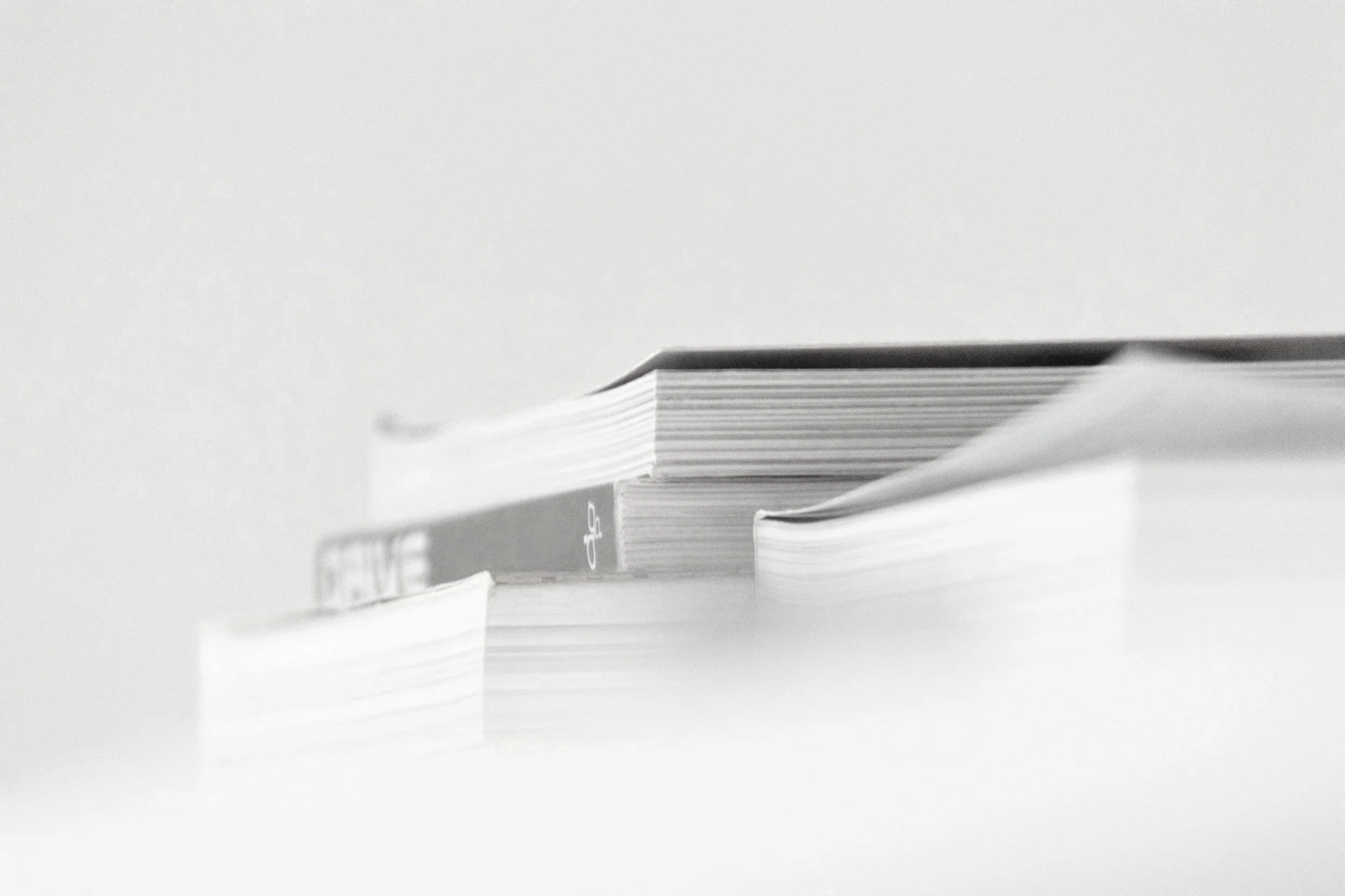 Close-up of a stack of papers or documents on a smooth surface with some papers slightly out of place.