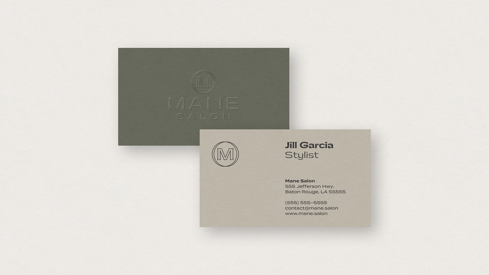 Business cards for Mane Salon with a beige card displaying the name Jill Garcia, stylist, and contact information, and a dark green card with a embossed Mane Salon logo.