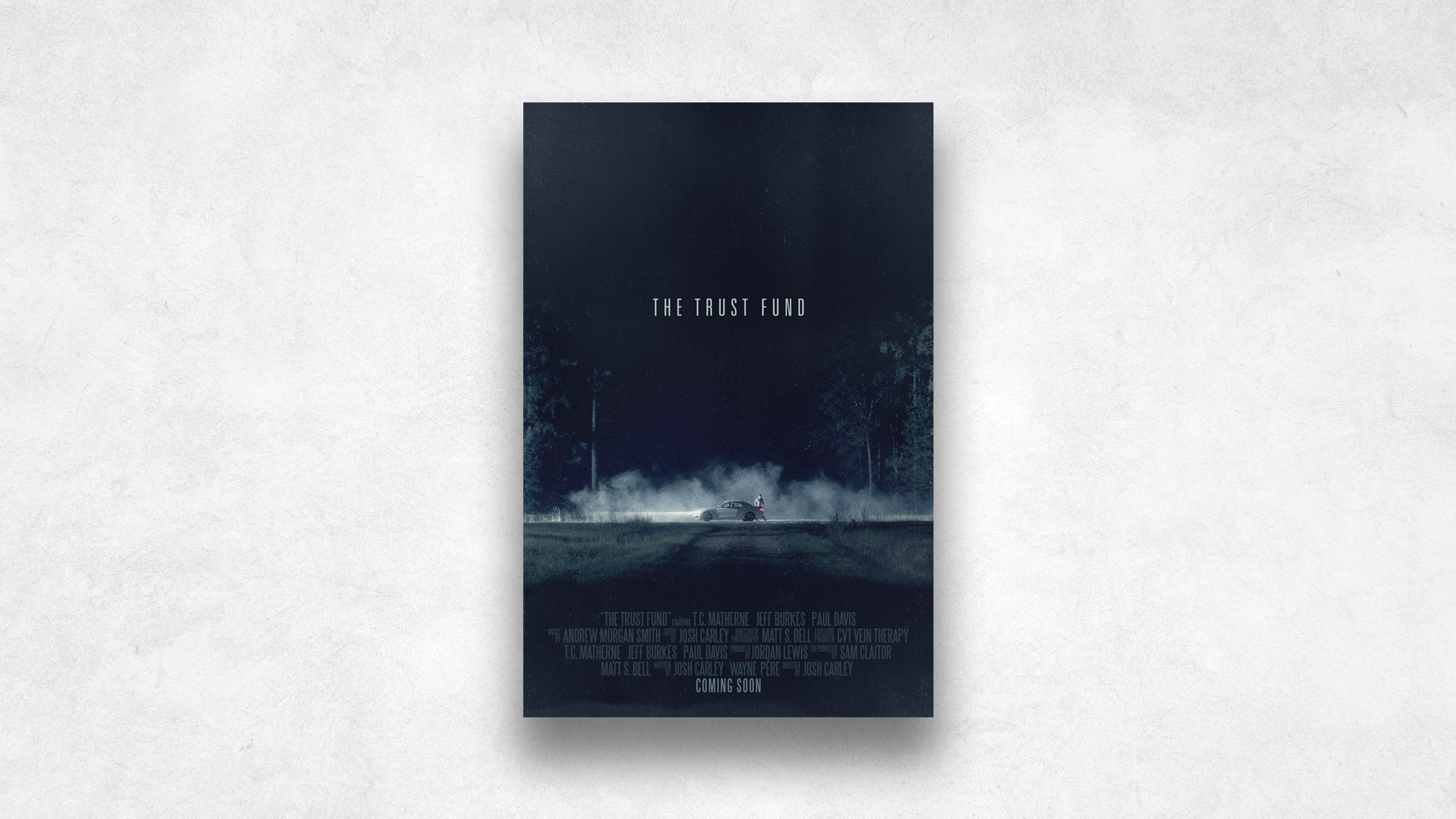 Movie poster for 'The Trust Fund' featuring a car on a road surrounded by a foggy, dark forest at night.