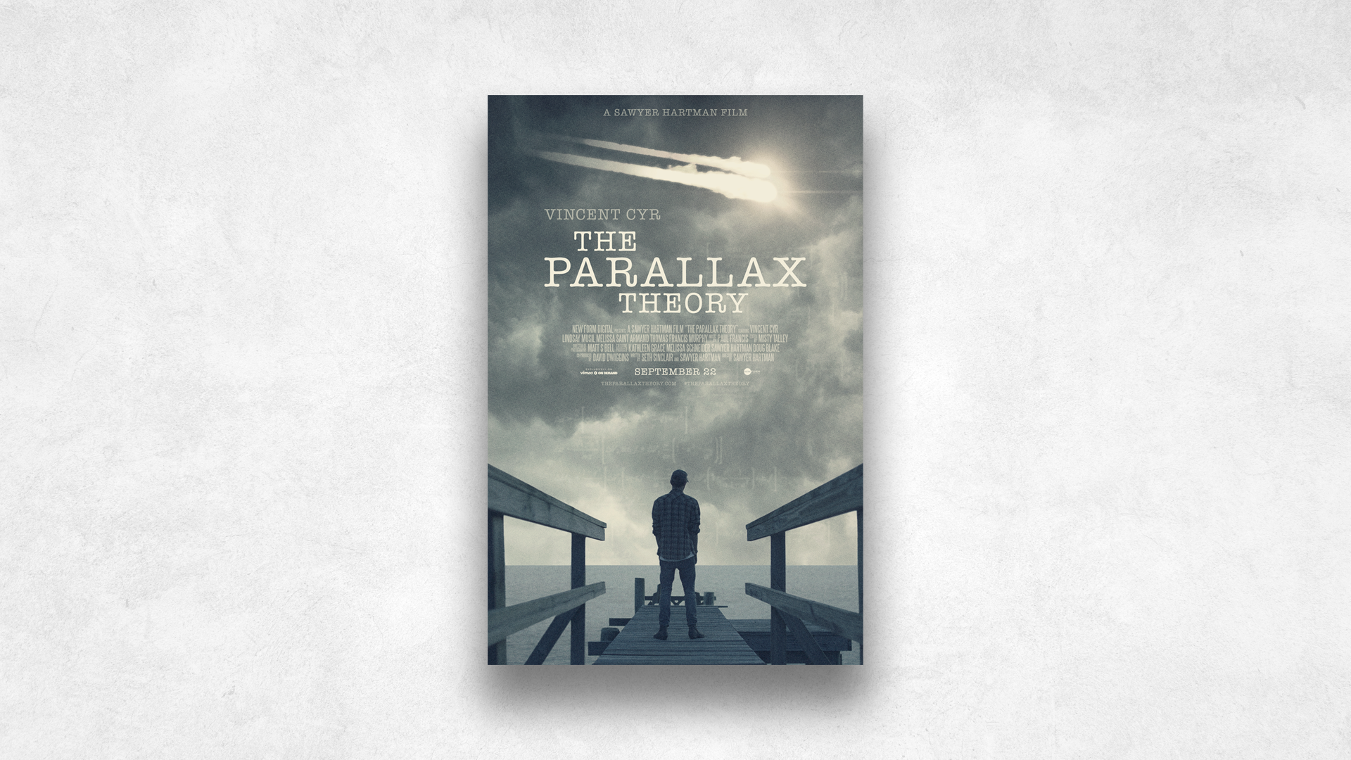 Movie poster for 'The Parallax Theory' showing a man standing on a dock looking at the sky with two meteors streaking through, overcast sky, and ocean in the background.
