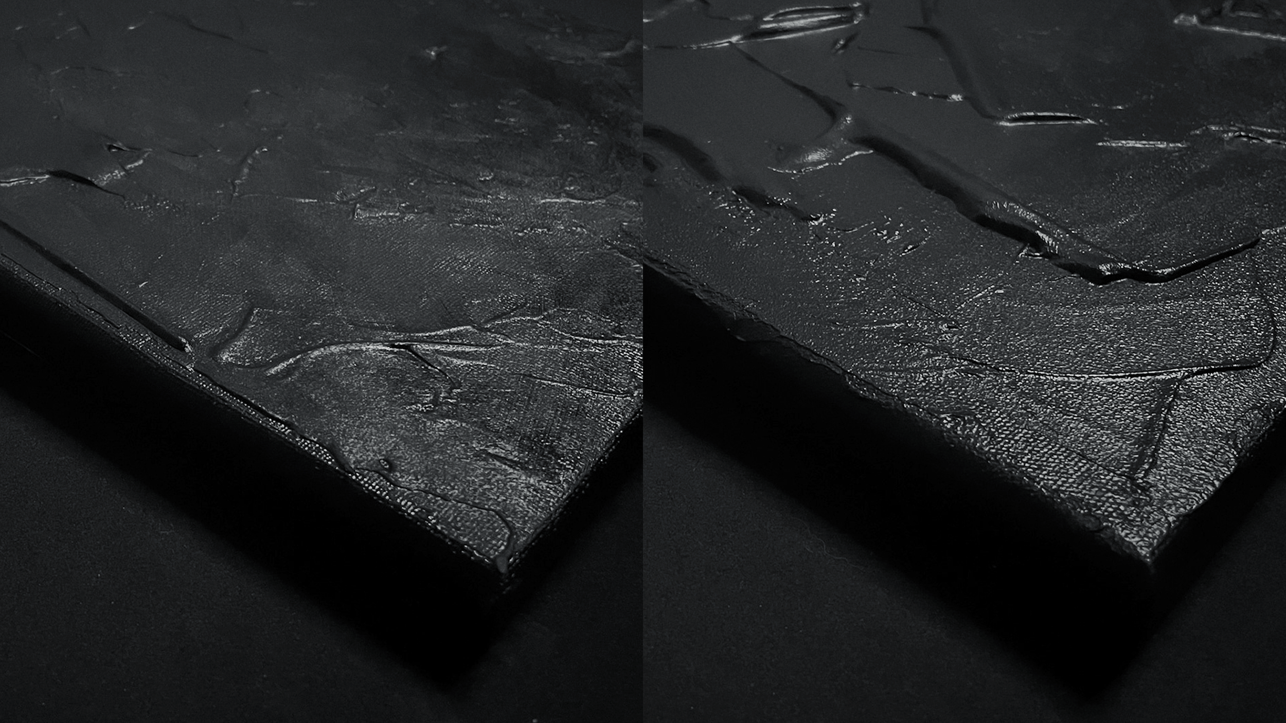 Close-up of a textured black slate surface with uneven, natural-looking cracks and fissures.