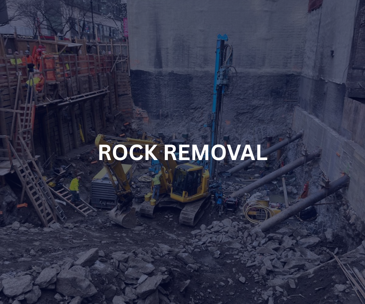 Construction site with workers and machinery removing rock and debris from an excavation area.