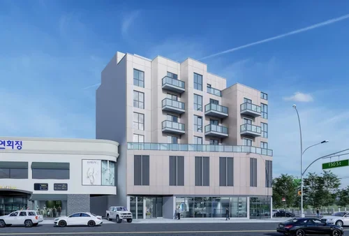 Modern multi-story building with balconies and a commercial storefront on the ground floor, parked cars in front, under a clear blue sky.