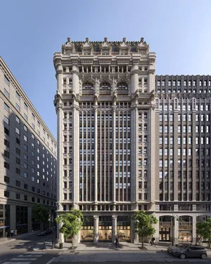 A tall, ornate historic building surrounded by modern skyscrapers in an urban setting.