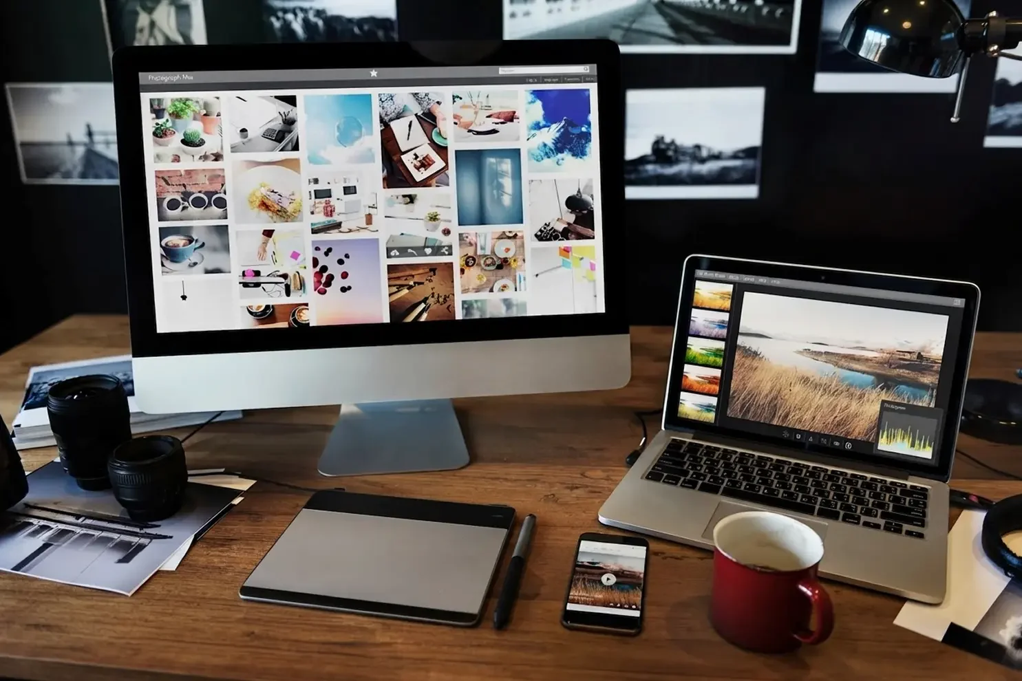 desktop monitor and laptop with coffee and mobile phone on web designer's desk