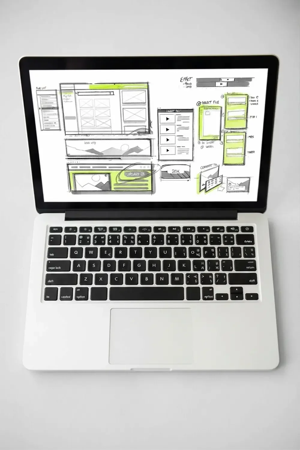 laptop displaying a wireframe website sketch on the screen, featuring various sections outlined for interface elements.